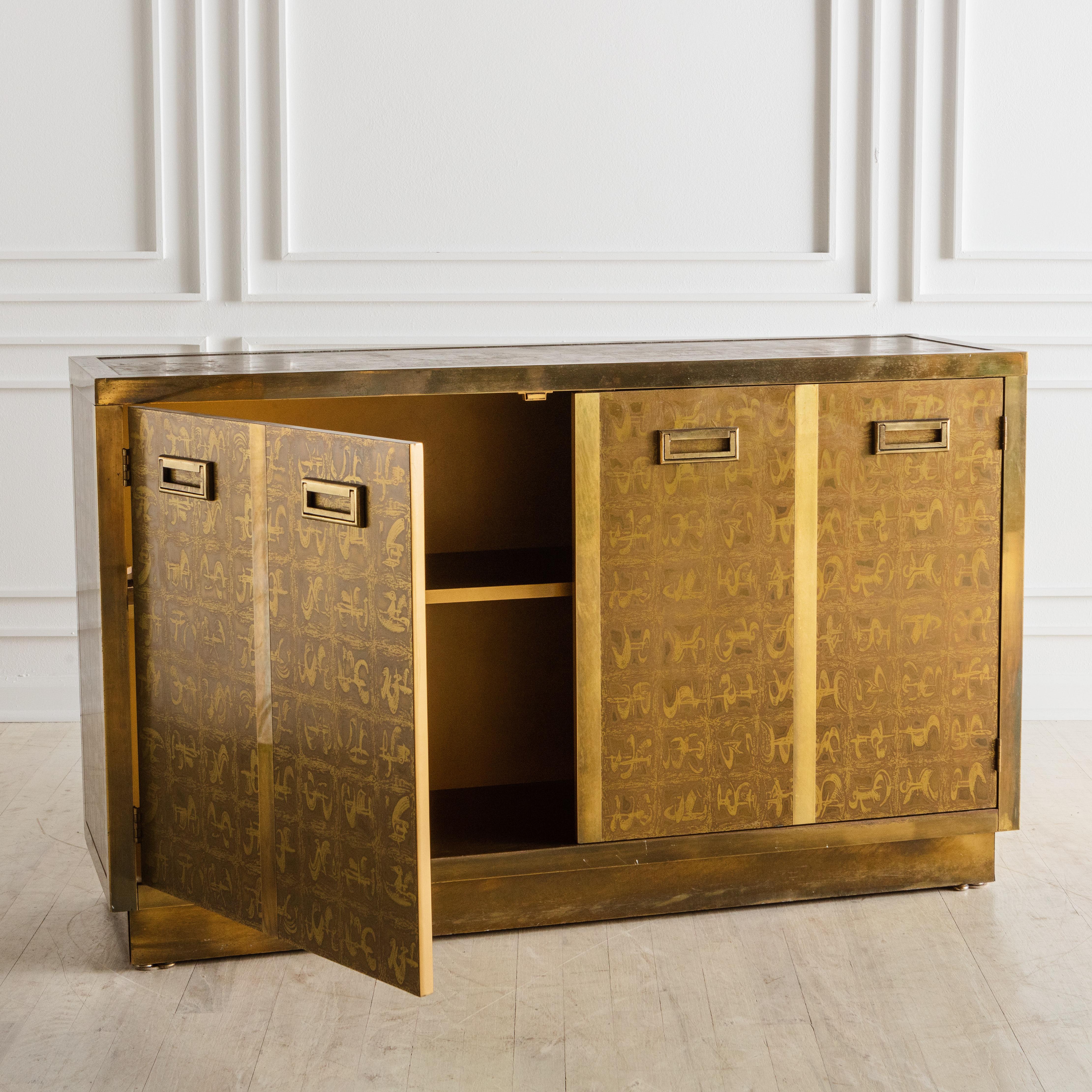 A statement piece designed by Berhard Rohne for the eponymous brand, Mastercraft. Featuring a gorgeous deep brass clad finish with repeating pattern created by the artist by etching the brass with acid. The cabinet doors open to reveal a single
