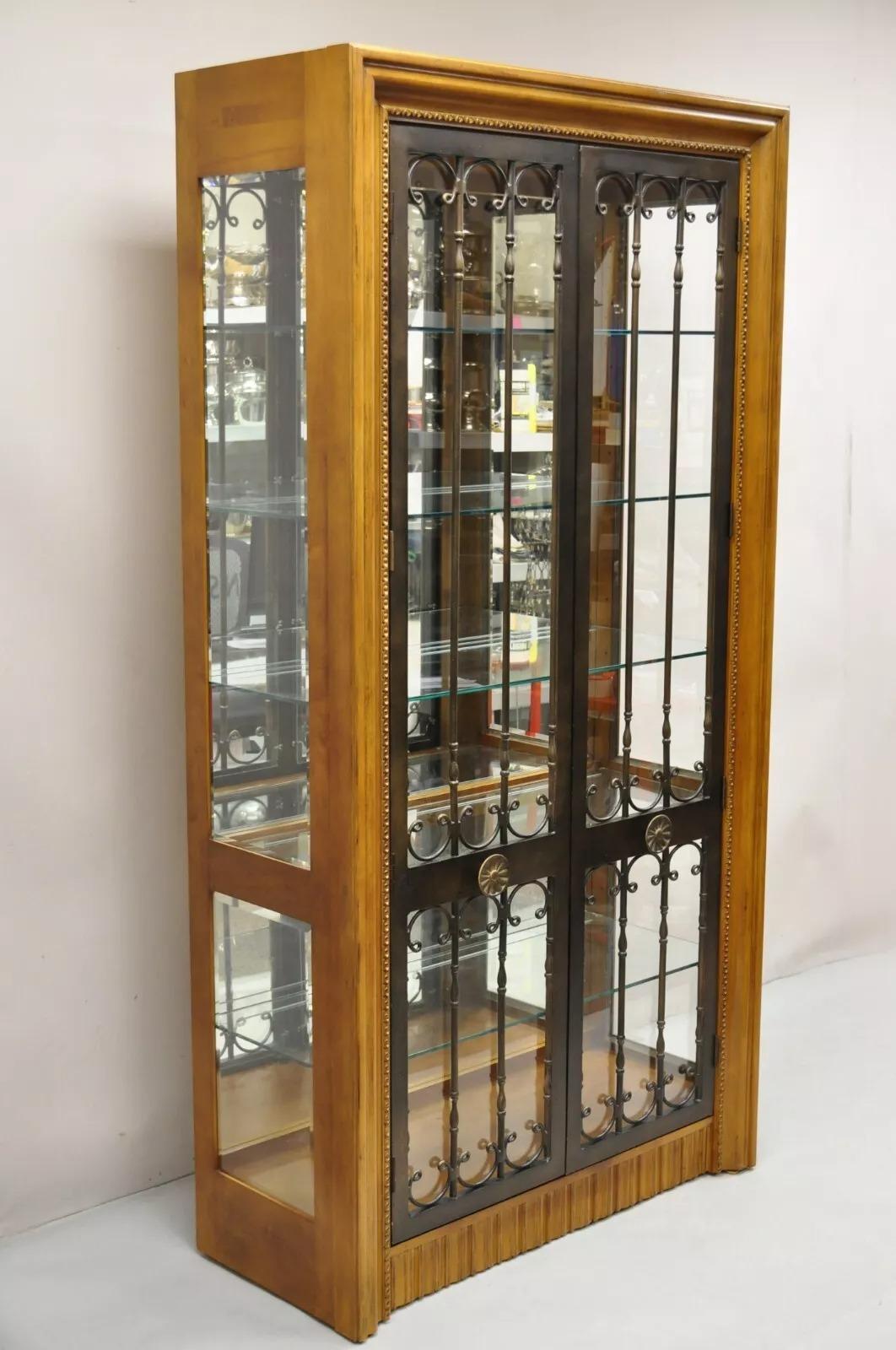 Bernhardt 354-356 Vitrina moderna de madera de cerezo y puerta de hierro con iluminación mediterránea. Detalles: Fondo de espejo, puertas de hierro ornamentadas, luz táctil con 3 niveles de iluminación, 4 estantes de cristal ajustables y 1 estante