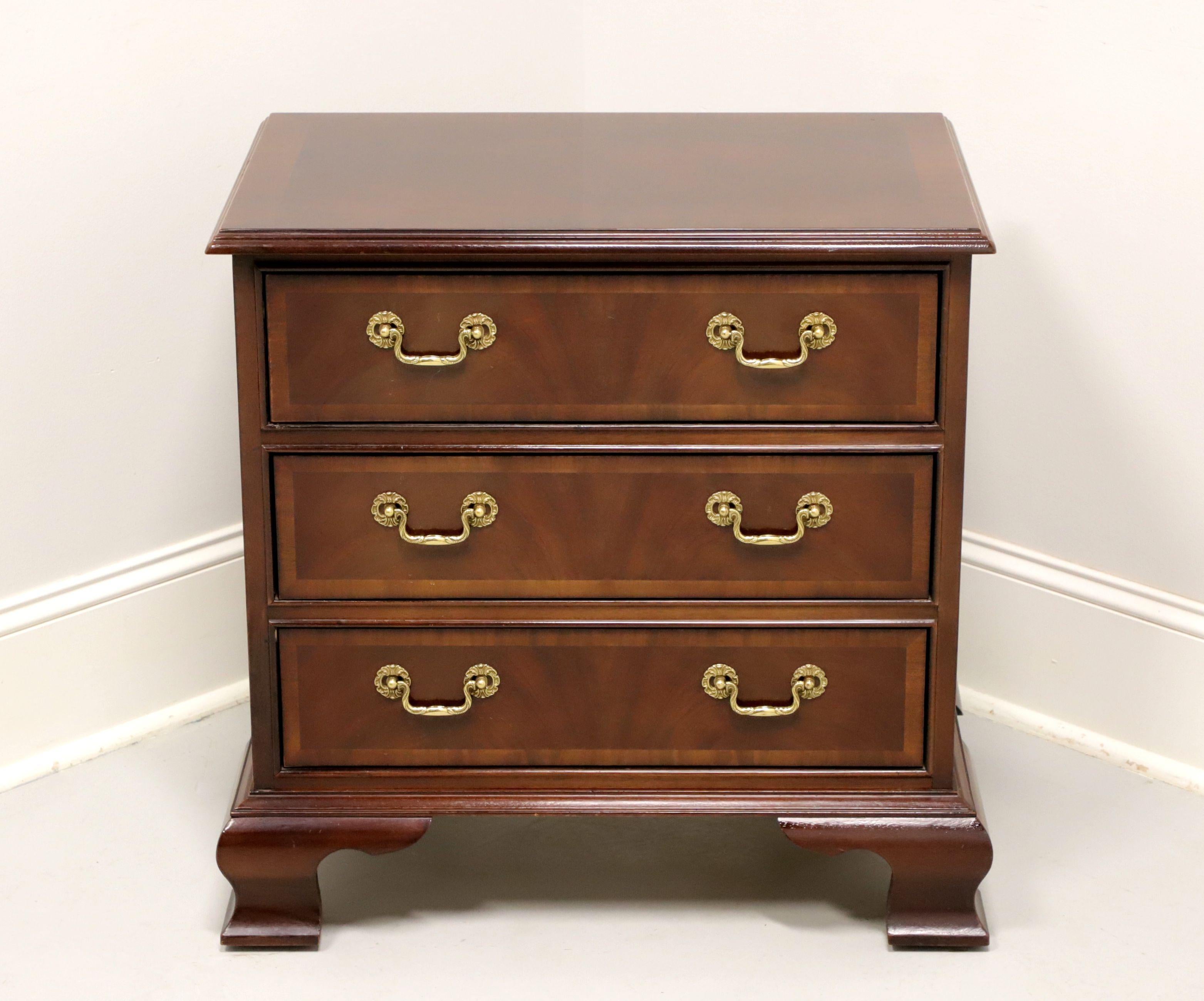 A Chippendale style chairside chest by Bernhardt, from their Centennial Collection. Mahogany, inlaid banded top with an ogee edge, brass drawer hardware & side handles, inlaid banded drawer fronts, fully finished back, and ogee bracket feet.