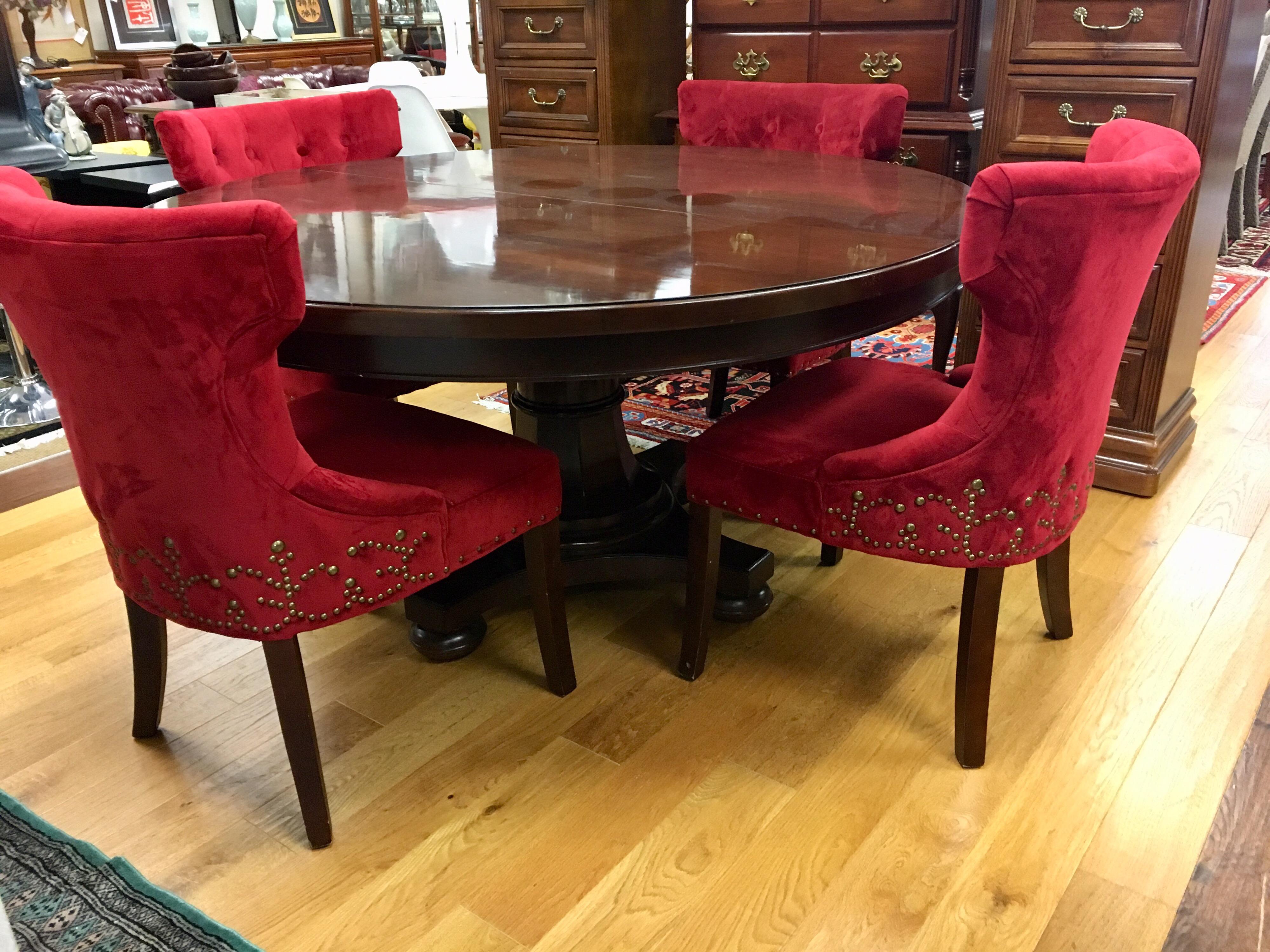 Stunning round Bernhardt mahogany dining room table with one leaf measuring 24 inches.
Comes with upholstered red chairs which were custom made and have red cotton upholstery and a one of a kind ornate nailhead pattern that almost looks like a work