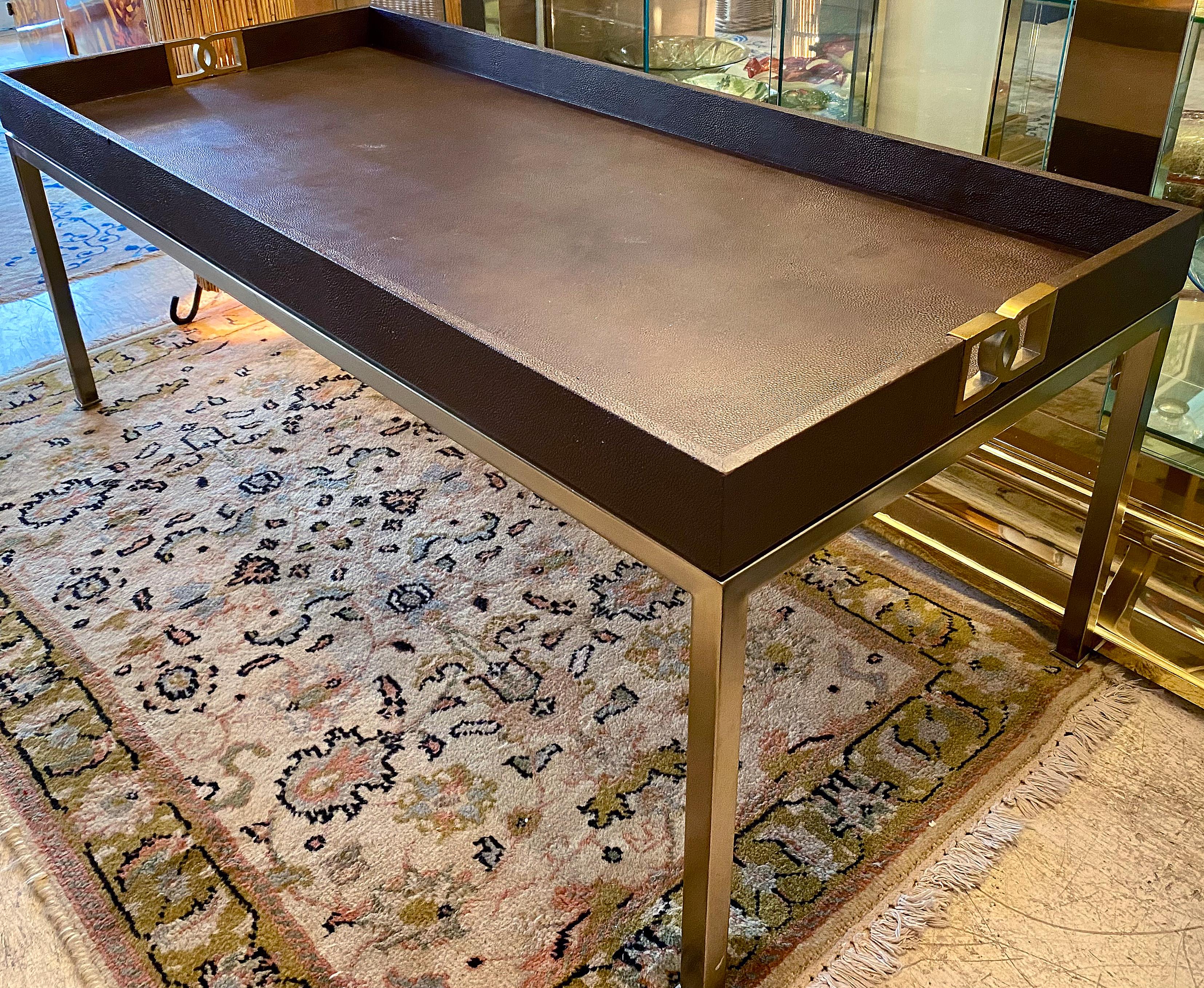 Offered for sale is an elegant Bernhardt faux shagreen and brass coffee table. The table has decorative cut-out handles at either end and a faux shagreen leather top which has the look of a tray top. The recessed space offers a rail to keep items