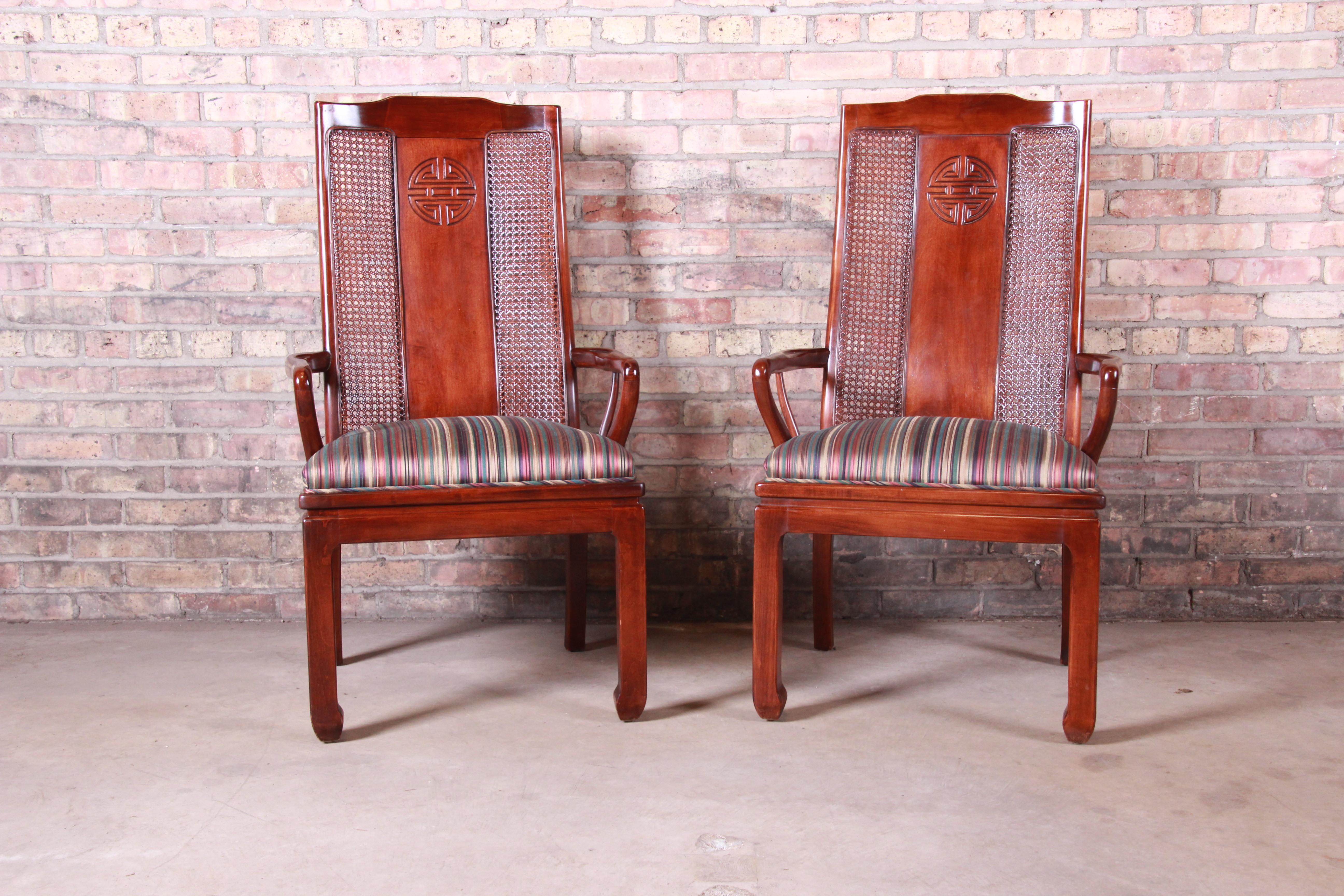 A gorgeous pair of Asian inspired armchairs. Perfect for dining captain chairs or club chairs.

By Bernhardt

USA, circa 1980s

Mahogany and cane, with upholstered seats.

Measures: 24