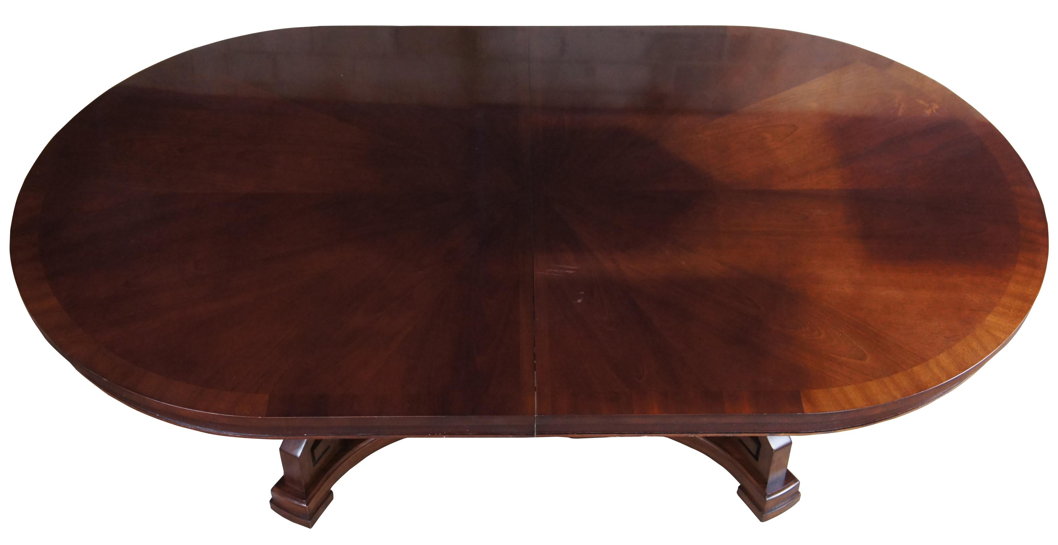 Berhhardt mahogany oval dining table. Features an Art Deco style base with Greek key and columnar supports, banded top and two large leaves for extention. Measures: 118