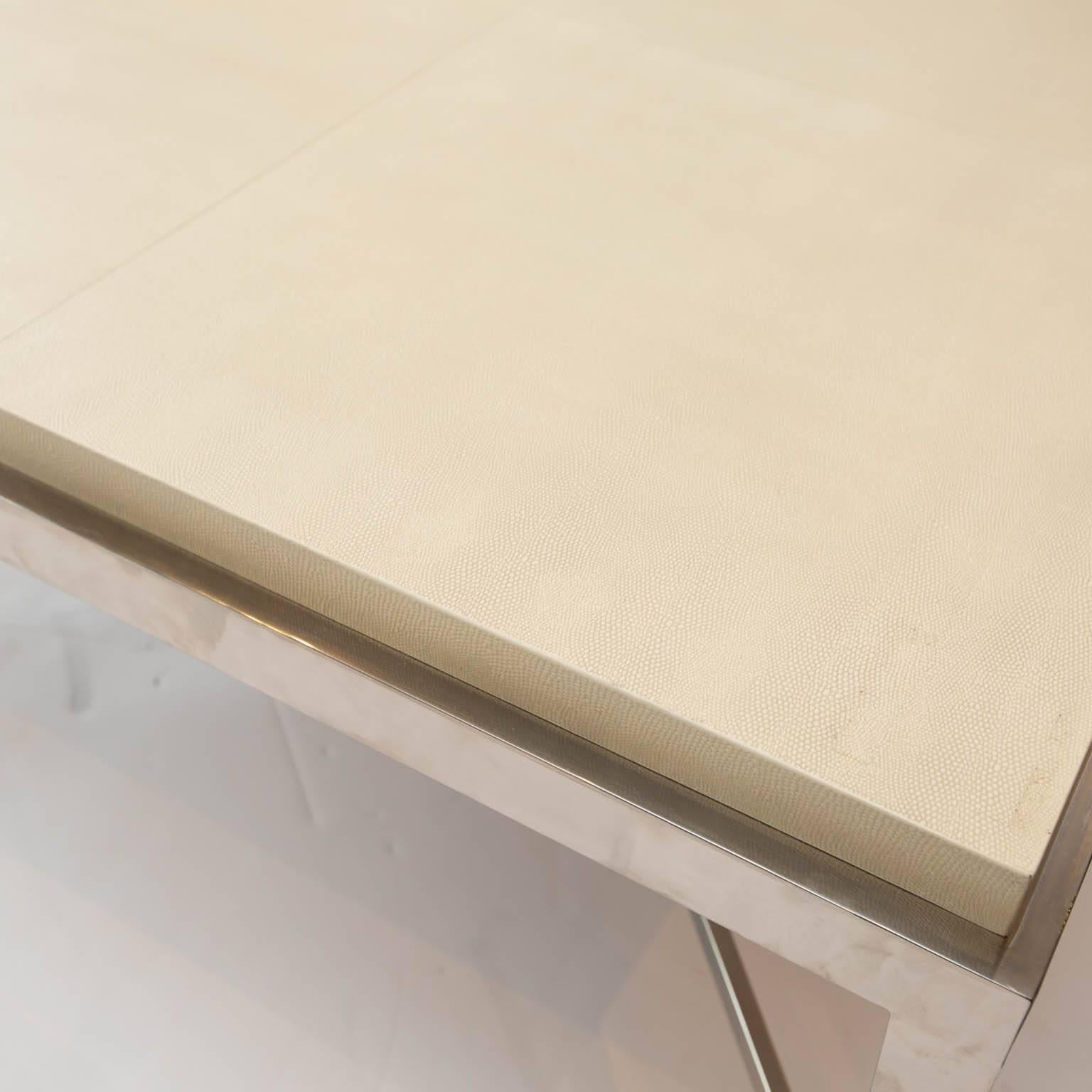 Used to stage a house, this large table by Berhardt features a white shagreen leather top resting on nickel plated stretcher base.