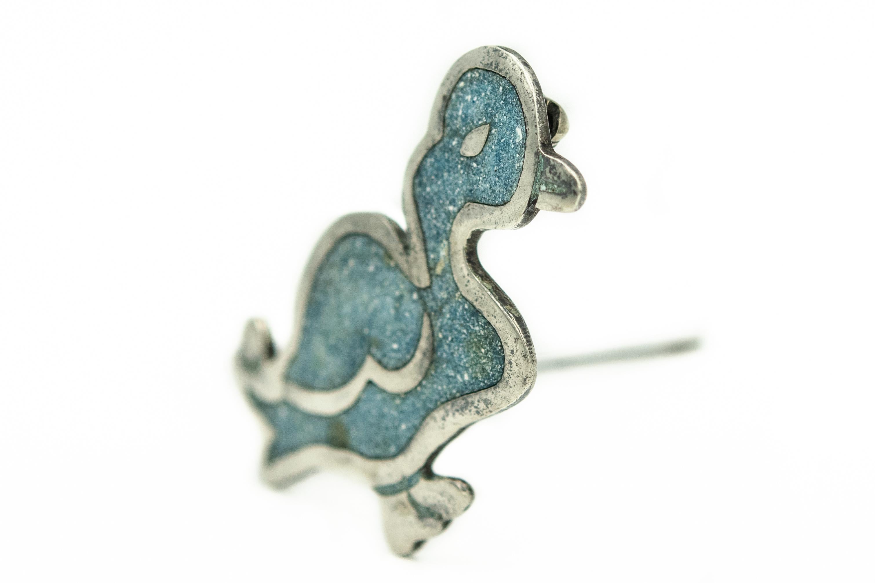 Hand wrought sterling silver duck brooch pendant with centrally set finely crushed, turquoise inlay.
HALLMARKS: TAXCO, MEXICO (circle), B (inside circle); STERLING; 925 with an Eagle assay stamp

In the 1930's, American-born Bernice I. Goodspeed