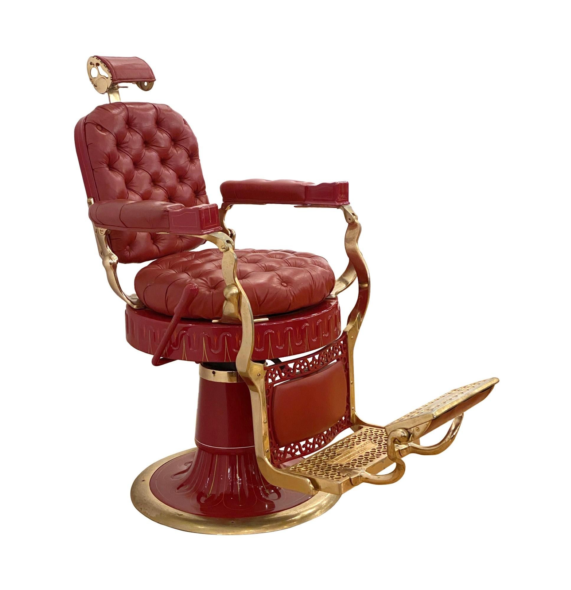 This top of the line antique Berninghaus Hercules barber chair has been restored. The chair has red tufted leather and a polished brass ornate frame. The Fine hand painted details along the base and seat complete its uniqueness. The hand crank works