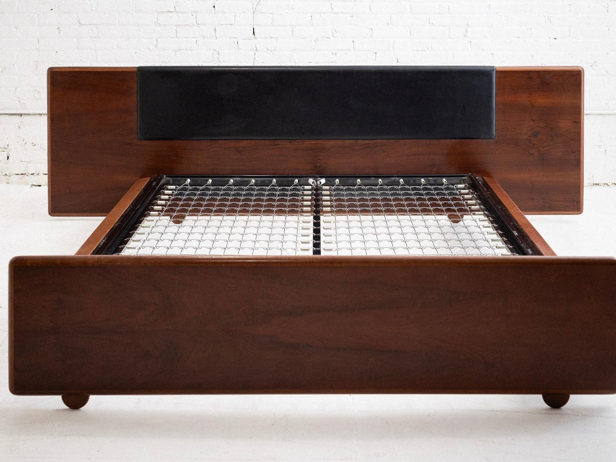A mid century Italian bed attributed to Bernini. Heavy and well constructed. Wood and leather headboard with wood footboard. Steel frame spring platform to support a mattress. Sourced in Northern Italy. Disassembles for transport.

Metal spring