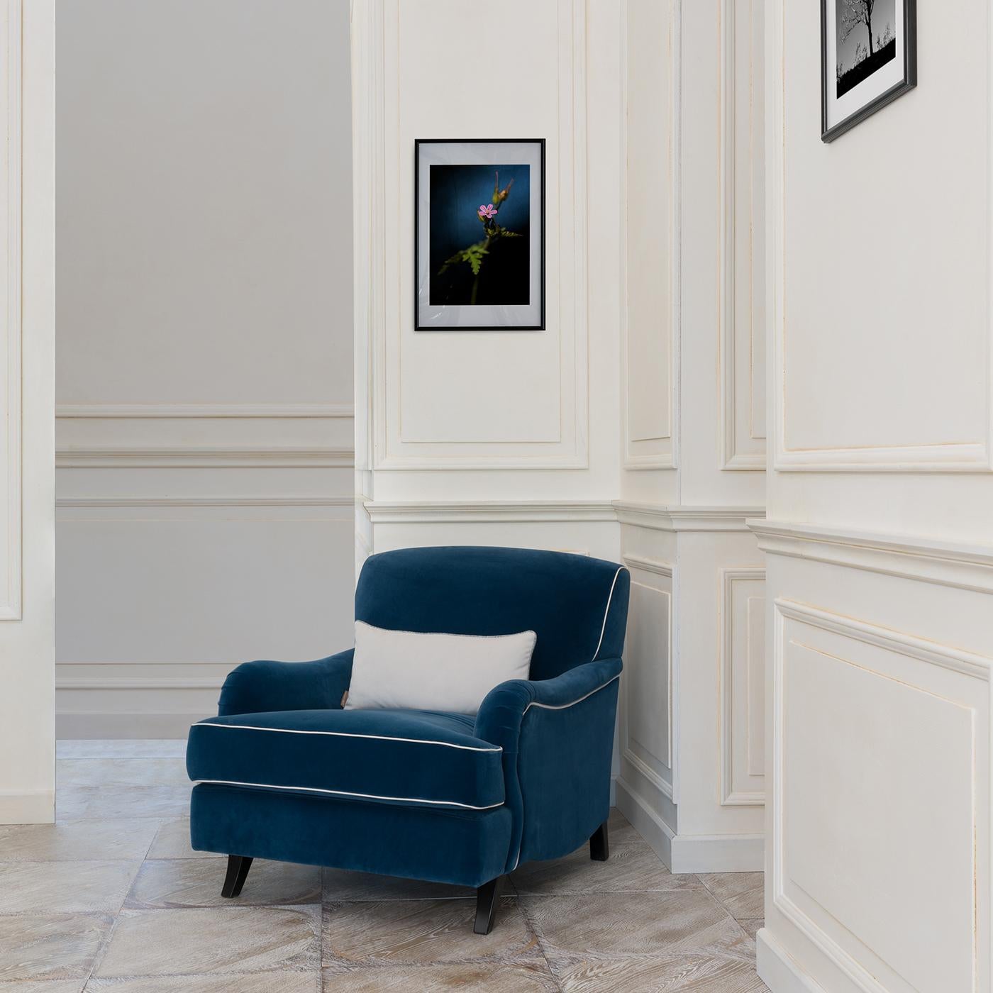 Any room will gain a touch of class with this English-inspired armchair from the Couture collection. This sophisticated chair is upholstered in plush, dark blue fabric with contrasting white piping and has a plush seat cushion and backrest and low,