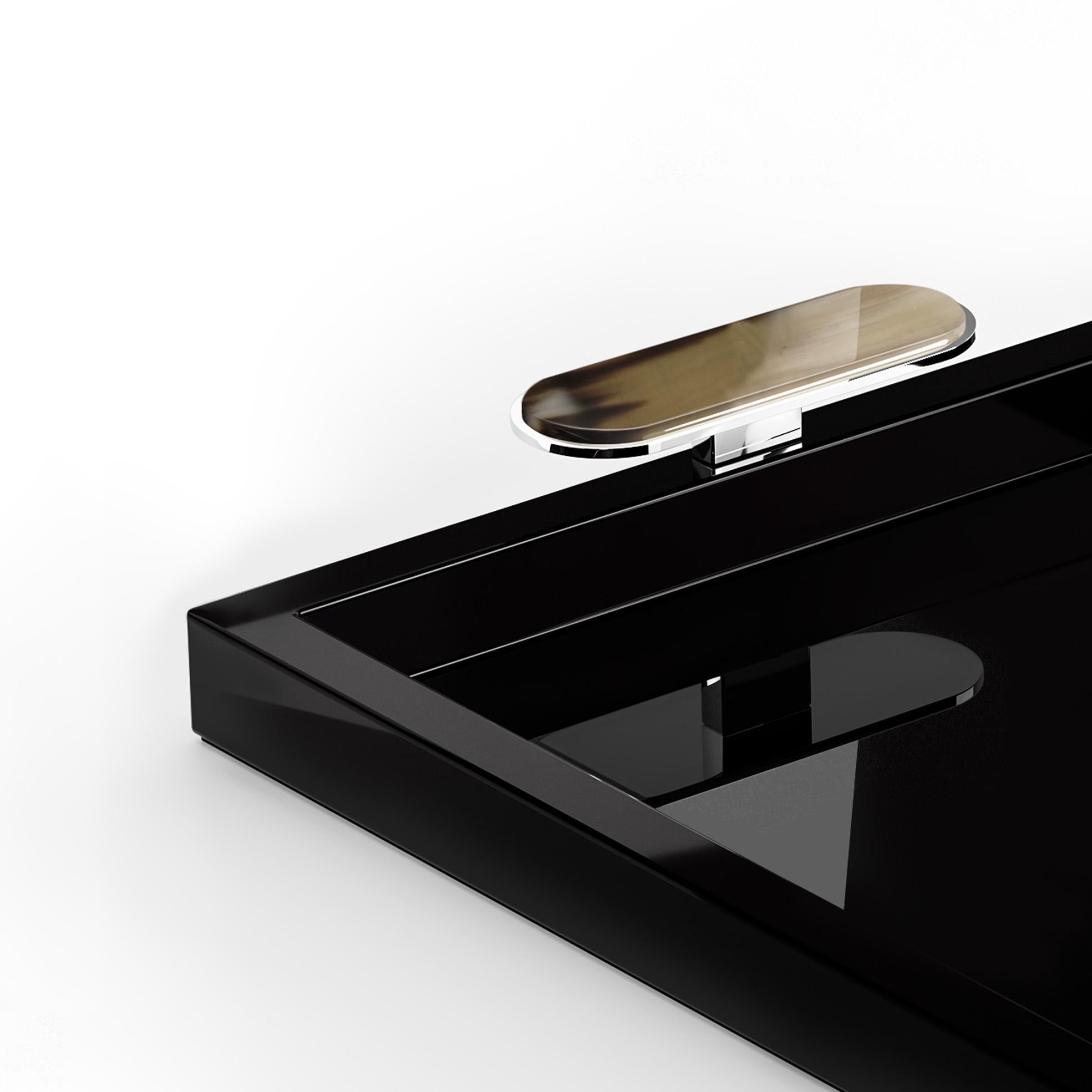 With its timeless elegance, Berro is the perfect tray to enhance your gatherings. Crafted from glossy black lacquered wood, the design is embellished by refined handles in Corno Italiano and chromed brass. Shaped by skilled artisans, the Corno