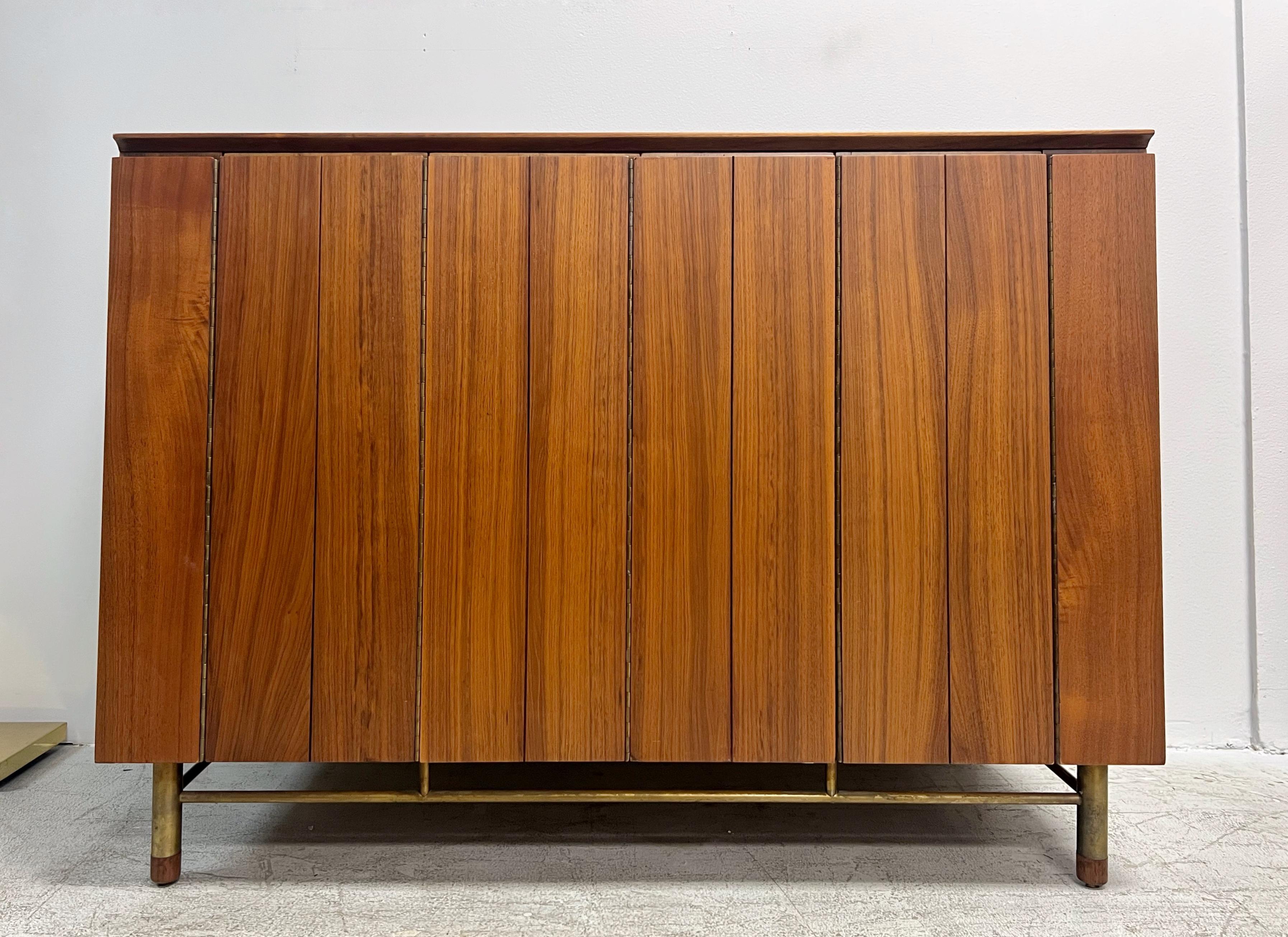 Un sofisticato mobile moderno di metà secolo disegnato da Bert England per John Stuart, caratterizzato da una noce riccamente scolpita e da un piano in ardesia levigata. Il design mette in mostra la raffinata sensibilità architettonica