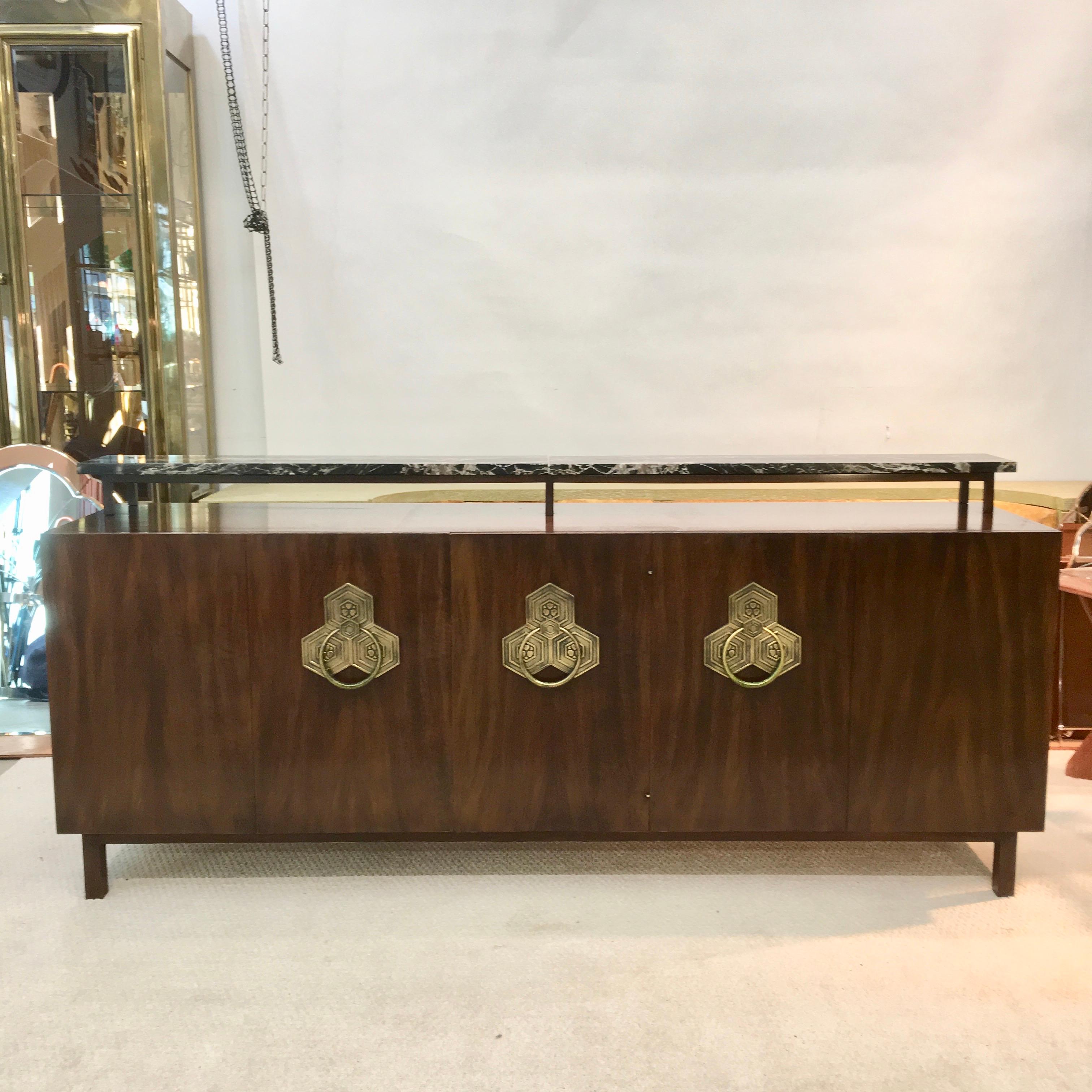 Designed by Bert England as part of the Orientation collection in 1965, this credenza was made for John Widdicomb, one of the finest furniture makers of the day. The impressive sideboard is in Persian walnut with a removable Nero Marquina marble