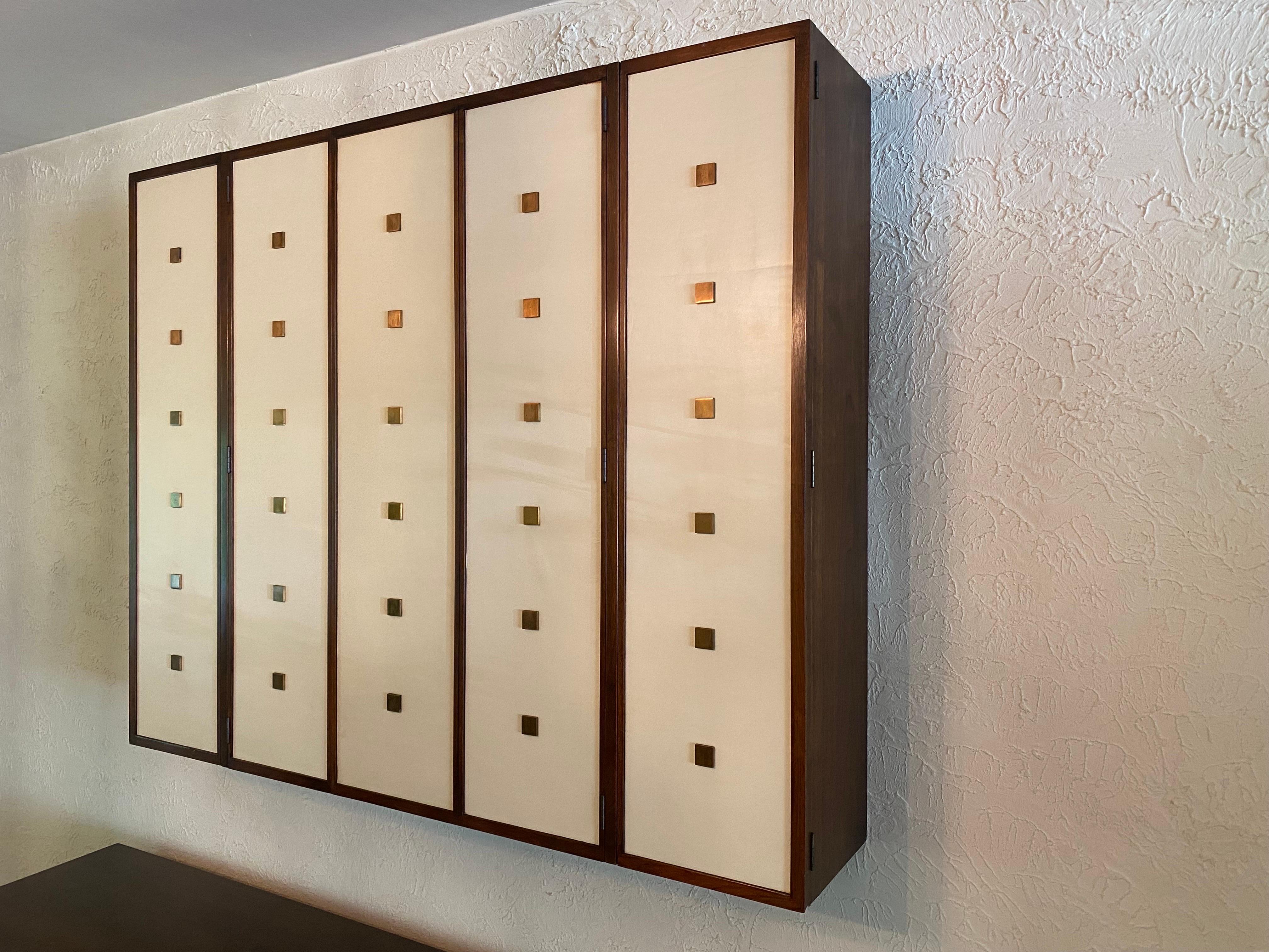 Bert England Hanging Wall Cabinet for Johnson Furniture Company of Grand Rapids Michigan.  Simple and Elegant!  Walnut body with vinyl covered doors and square bullets.  Perfect for Stemware or as a back bar!  Adjustable shelves throughout! 