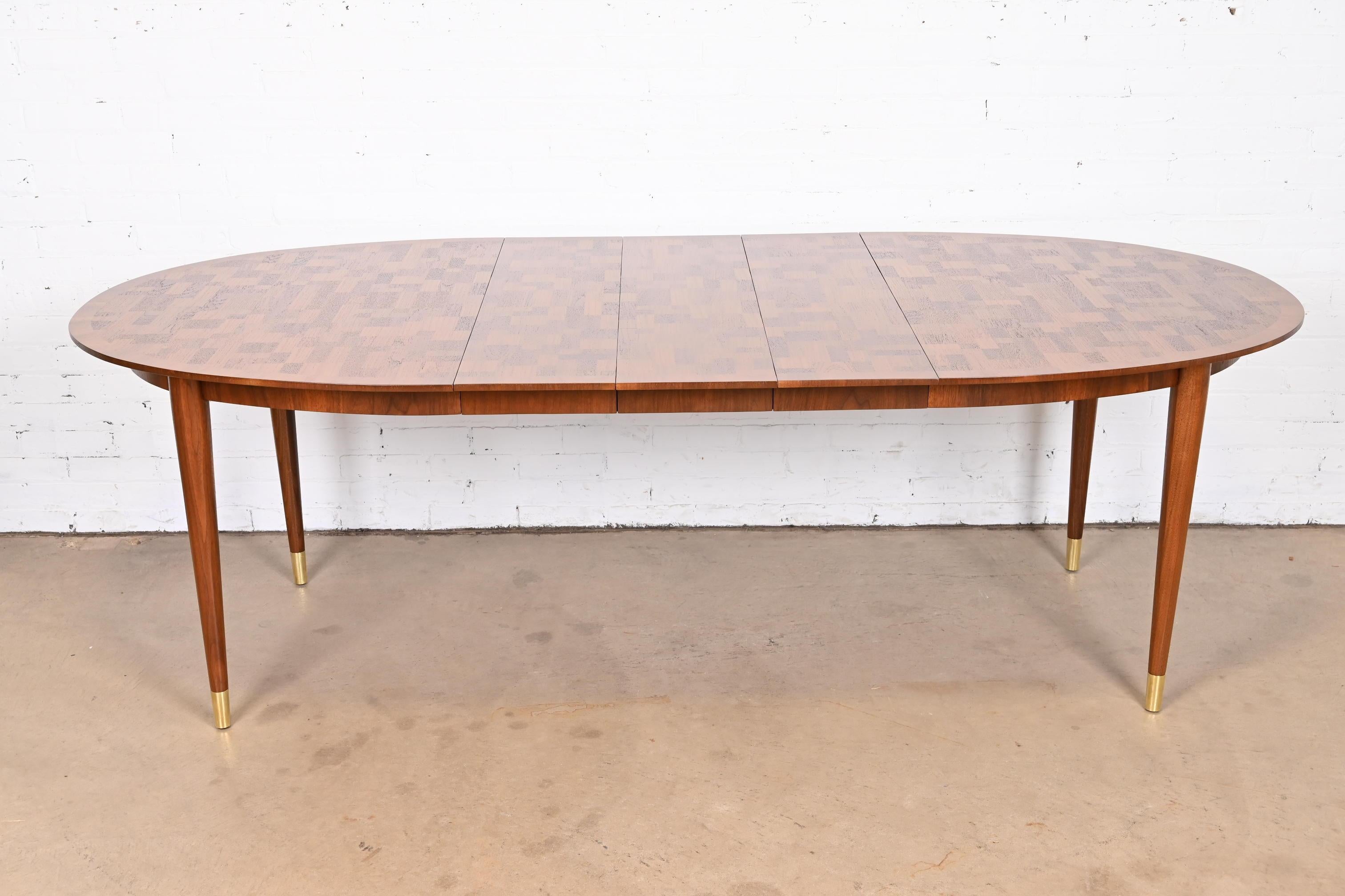An exceptional Mid-Century Modern extension dining table

By Bert England for Johnson Furniture

USA, 1950s

Gorgeous inlaid walnut patchwork parquetry top, with tapered solid walnut legs terminating in brass ferrules.

Measures: 60