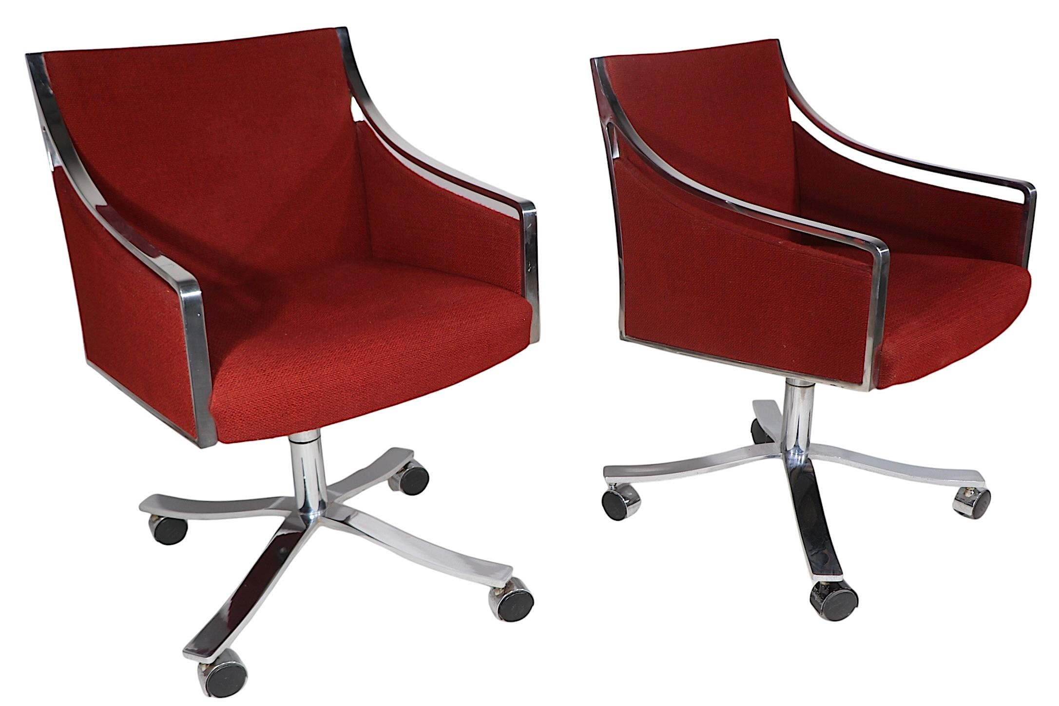 High end swivel desk chairs designed by Bert England for Stow Davis, circa 1970's. The chairs feature heavy bright steel frames, bases and legs, with original fabric upholstered backs and seats. The chairs tilt, and  swivel a full 360 degrees, the