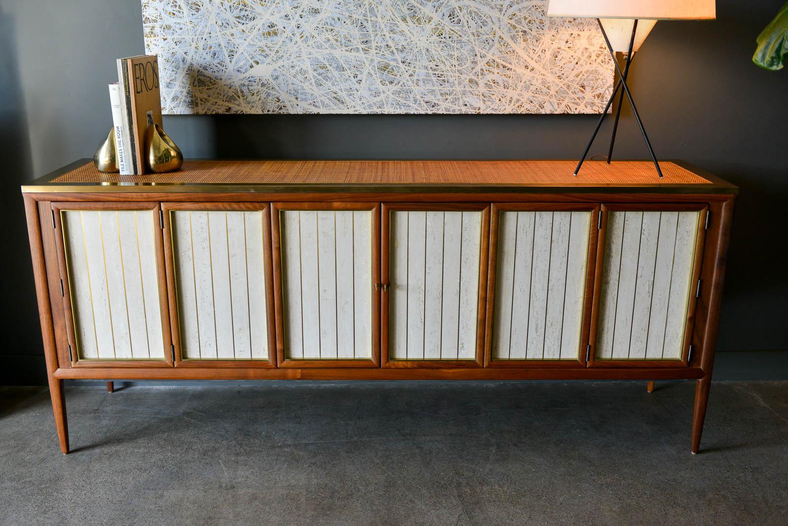 Bert England walnut, cane, brass and travertine credenza, circa 1955. One of the most beautiful pieces you will ever see with exceptional craftsmanship and design, this beautiful walnut credenza checks all the boxes. Made of solid walnut with cane