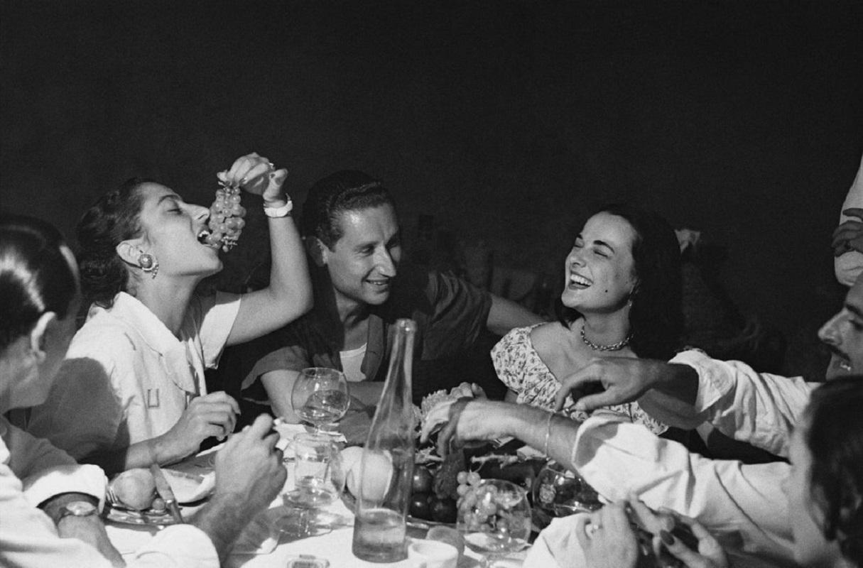 "Italienische Party" von Bert Hardy

September 1949: Der Bürgermeister von Positano gibt eine Party für Mercy Haystead (rechts), eine 18-jährige Londoner Studentin, die als offizieller Gast der Stadt Positano in Italien Urlaub macht. Ursprüngliche