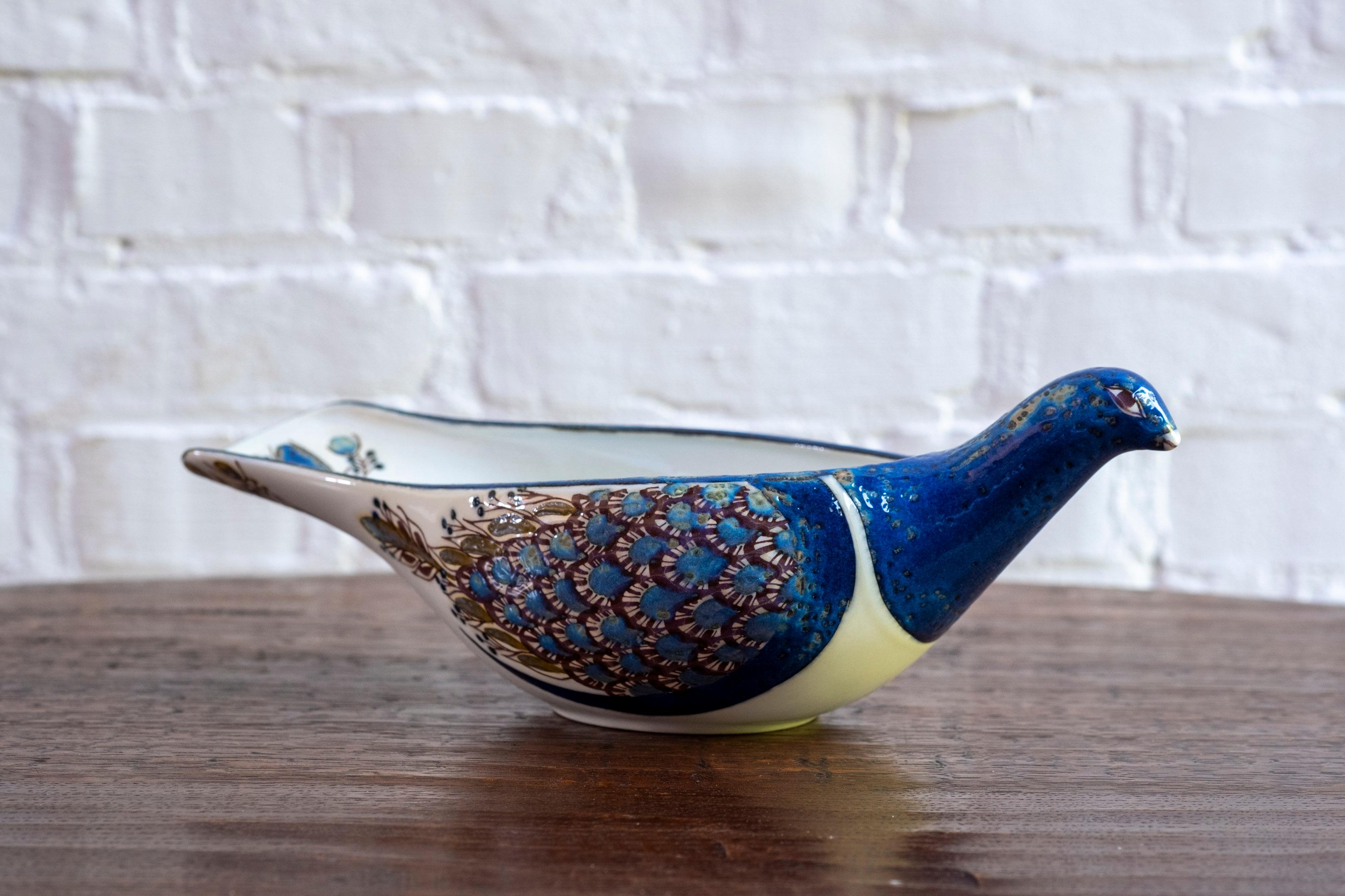 Rehaussez votre intérieur et votre collection avec cet exquis plat à oiseaux conçu par la célèbre artiste céramiste danoise Berte Jessen pour Royal Copenhagen. Connue pour ses designs distinctifs et ludiques, l'œuvre de Design/One est très