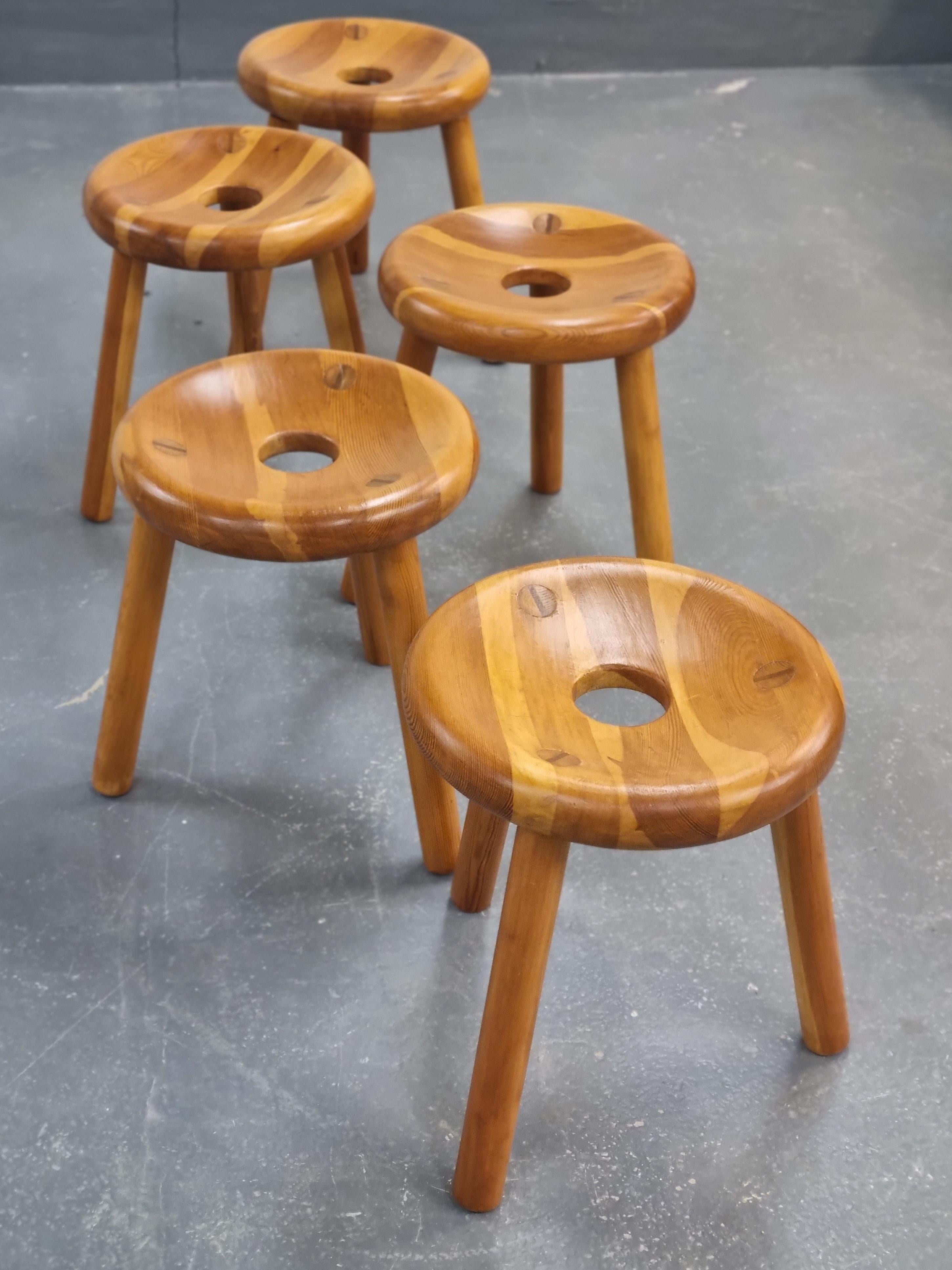These amazing stools were designed by marvelous Finnish designer Bertel Gardberg (1919-2007) in 1950s'. 

He was the master of form and function. The stools are varnished pinewood and they have 4 parts: three legs and a round hollow seat with a hole