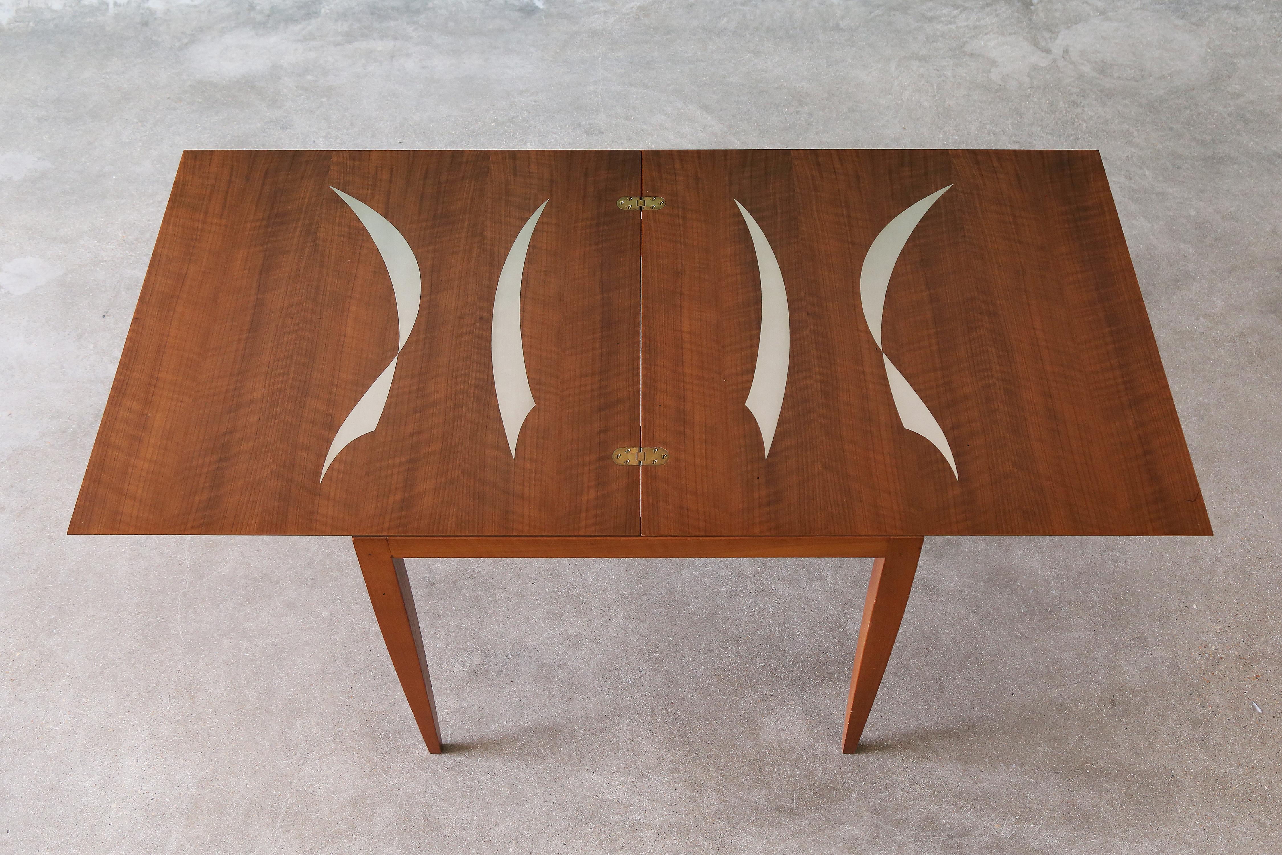 Table de salle à manger en noyer italien avec incrustations en aluminium, fabriquée par Singer and Sons.  Le design est attribué à Bertha Schaefer, mais Gio Ponti et Ico Parisi travaillaient également pour Singer and Sons à l'époque.  De belles