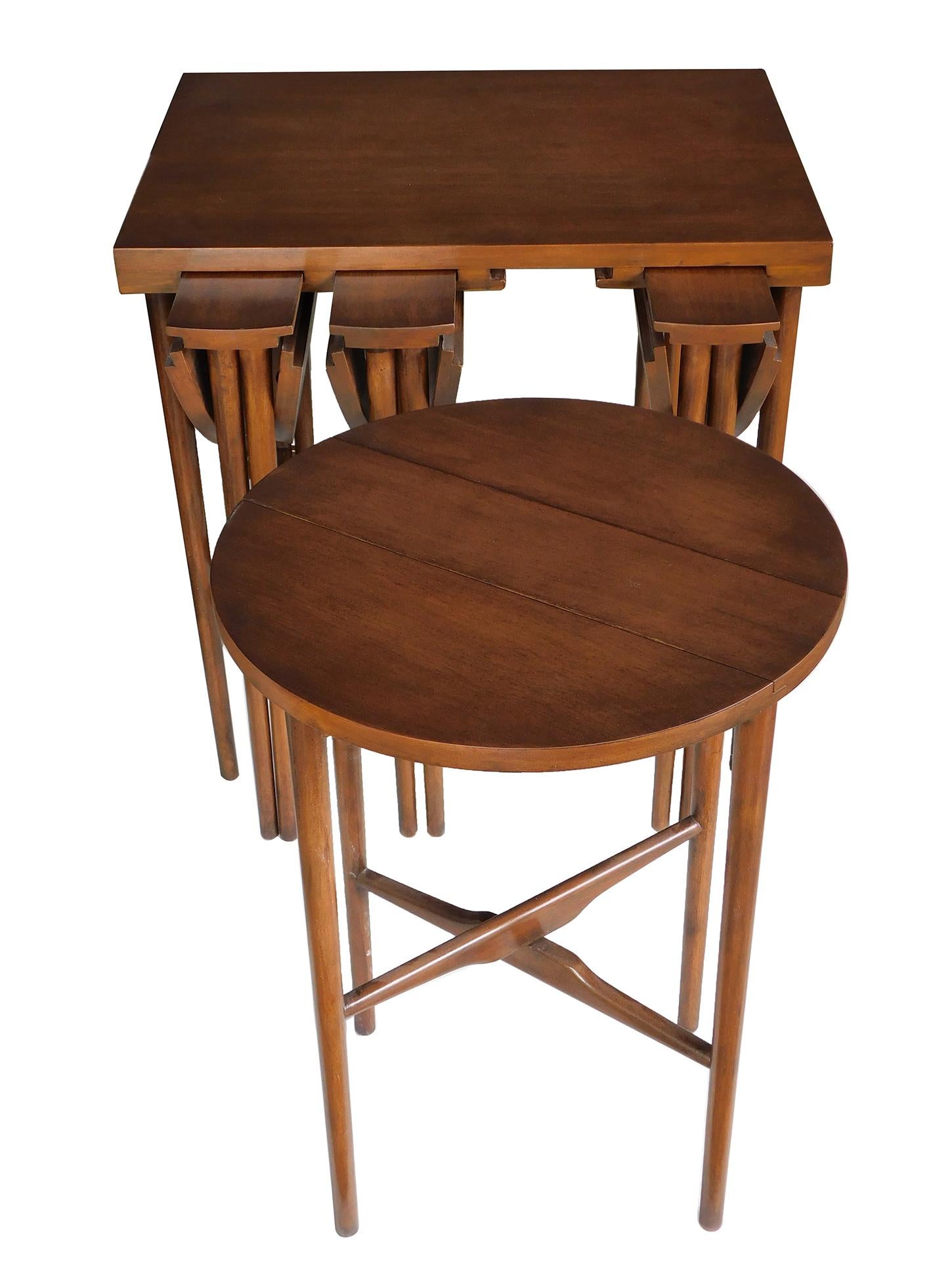 Cet ensemble de tables gigognes du milieu du siècle conçu par Bertha Schaefer (Américaine, 1895-1971) pour M. Singer & Sons est composé d'une table rectangulaire munie en dessous de 4 tables rondes pliantes suspendues à des fentes ; avec un Label