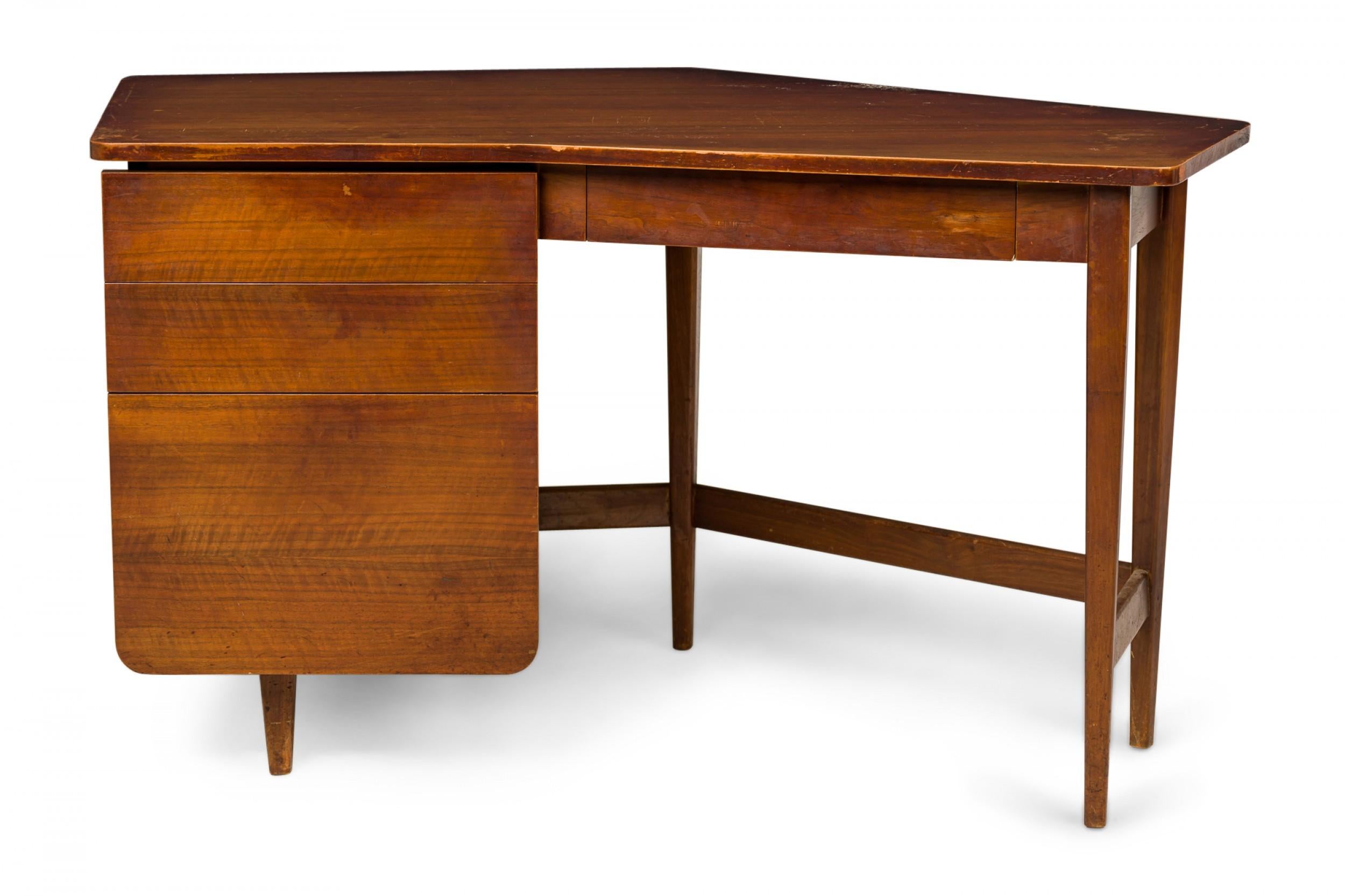 American Mid-Century walnut writing desk with an angular top and two left-hand drawers, supported by five tapered dowel legs connected by stretchers. (BERTHA SCHAEFER FOR SINGER & SONS)