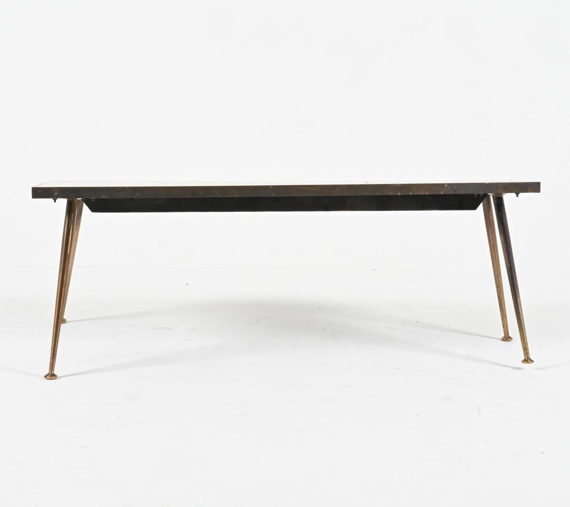 Luxurious materials and fine craftsmanship meet fabulous Mid-Century design in this exceptional and rare Atomic Modern coffee table by the German sculptor Berthold Muller, produced in Germany in the 1950's. This piece features a solid brass frame,