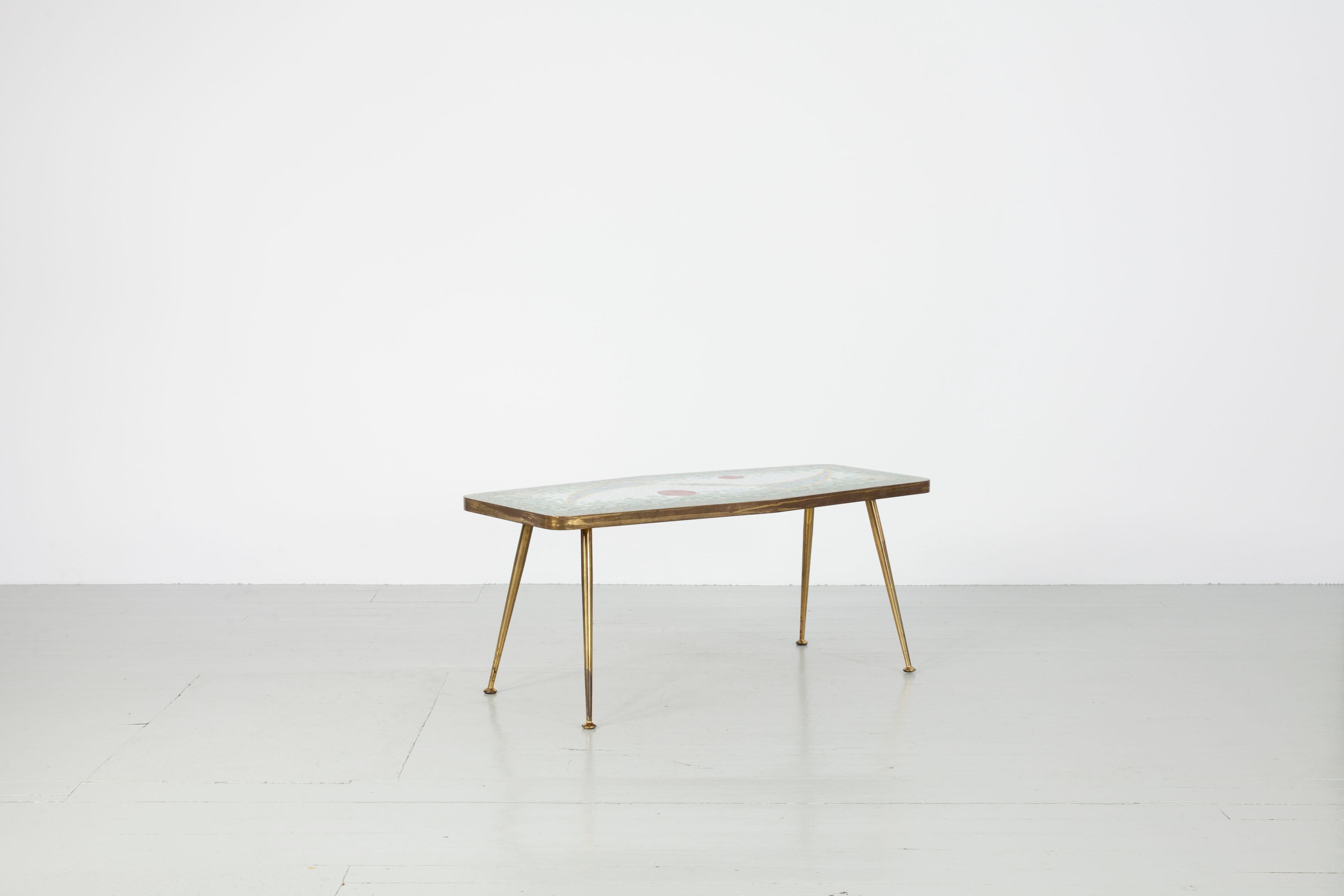Cette table en mosaïque a été conçue par Berthold Müller en Allemagne dans les années 1950. Le plateau de la table est dans des tons pastel de vert, de bleu et de jaune et présente un moment de contraste avec des sphères rouges. Cette mosaïque est