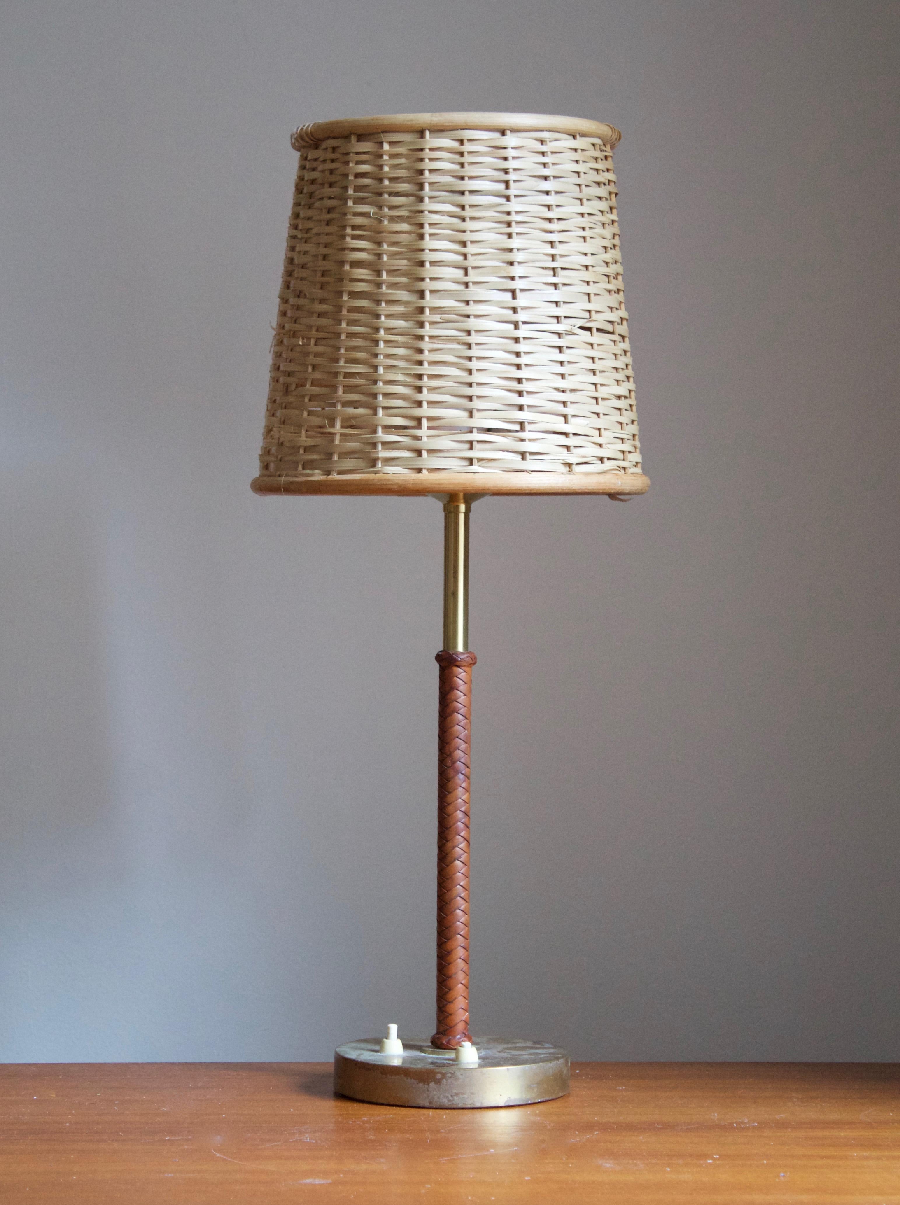 A table lamp, designed by Bertil Brisborg for Nordiska Kompaniet. Produced 1940s.

Features braided leather, brass, and an assorted rattan lampshade.