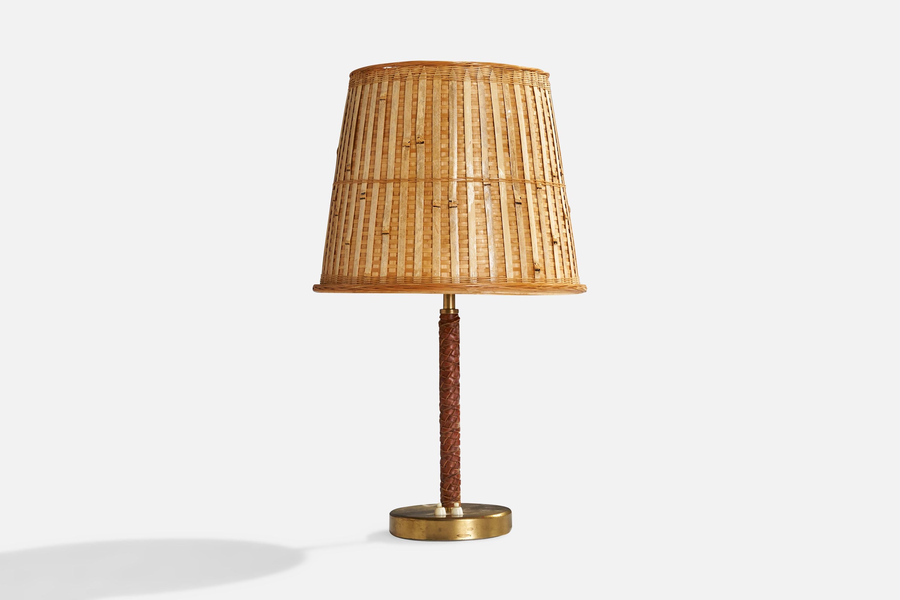 Lampe de table en cuir brun tressé, laiton et rotin, conçue par Bertil Brisborg et produite par Nordiska Kompaniet, Suède, années 1940.

Abat-jour en rotin vintage assorti.

Dimensions globales (pouces) : 24