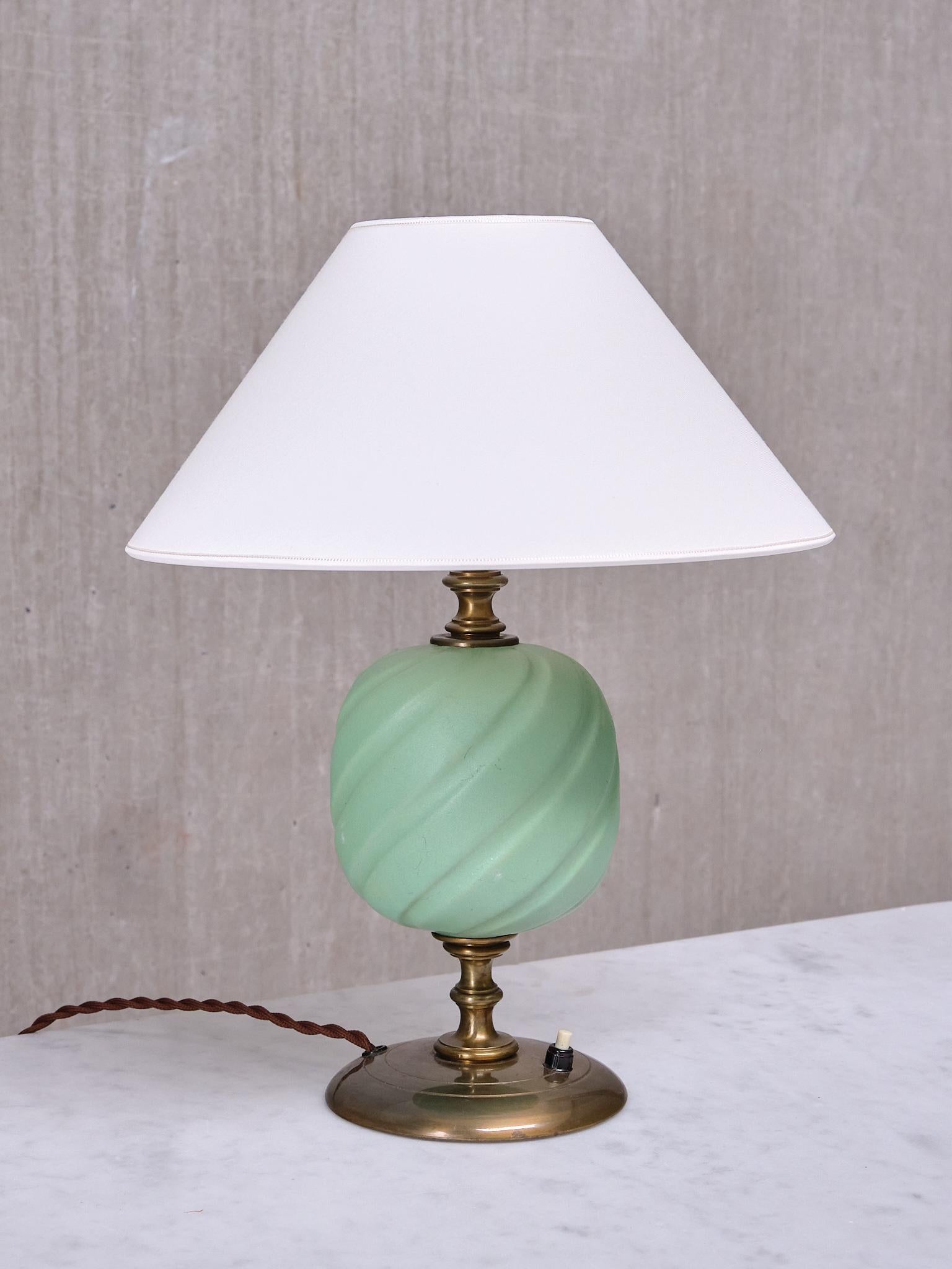 Cette lampe de table très rare a été conçue par Bertil Brisborg et produite par Nordiska Kompaniet en Suède à la fin des années 1940.

Le design se distingue par sa base circulaire et sa colonne centrale en laiton patiné à l'ancienne. L'élément