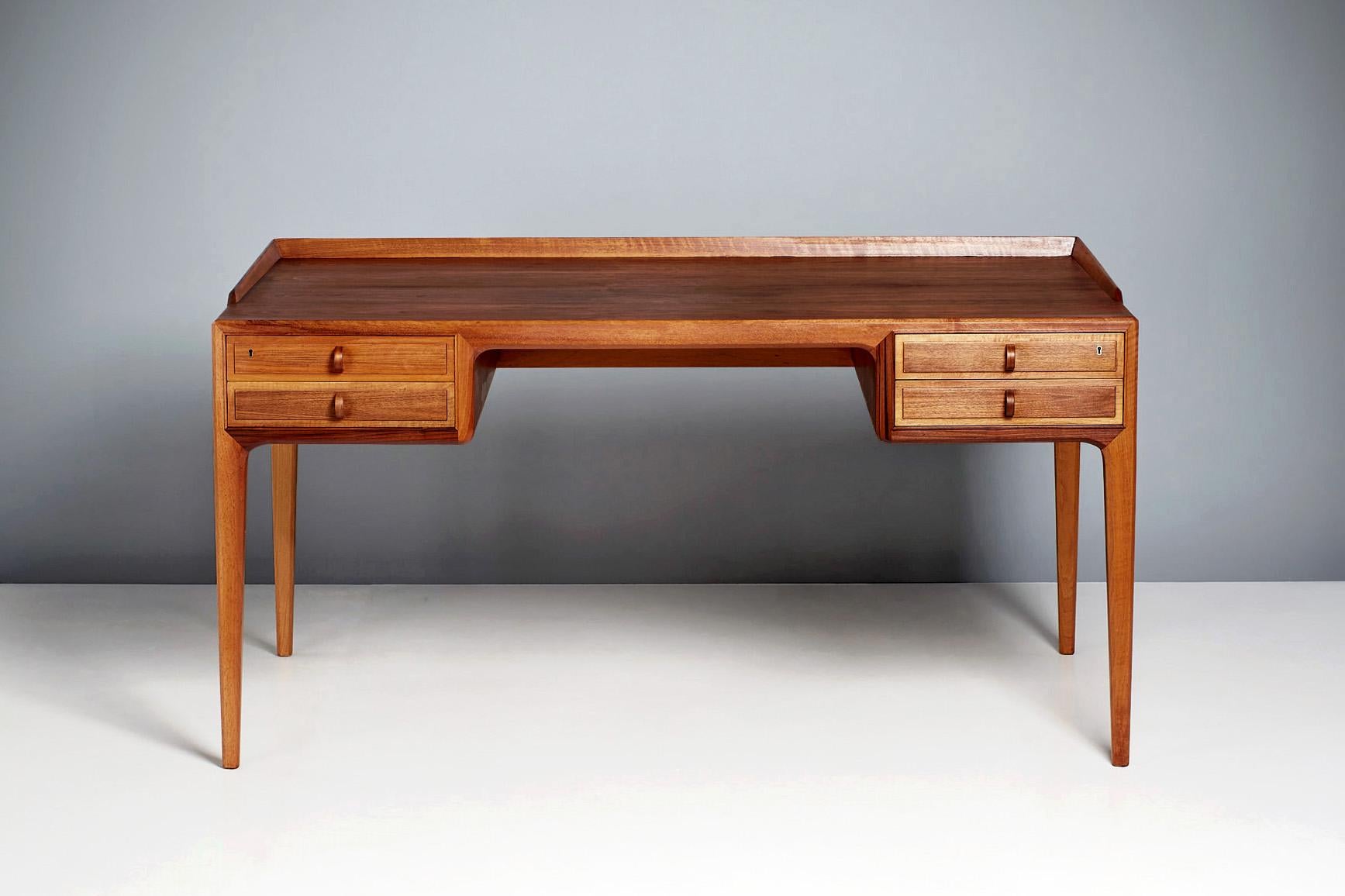Bertil Fridhagen Writing desk produced by Swedish cabinetmakers Bodafors in 1962.

This compact desk features elegant tapered and chamfered legs, a ridge around the sides and back of the desk and has 2 sets of drawers either side of the central
