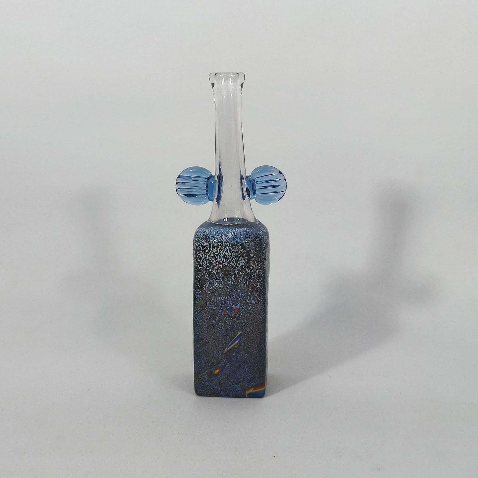 Very rare Bertil Vallien Atelje glass vase, Sweden, 1970s
Early vase designed by Bertil Vallien and made at the Boda factory in the 1970s. The vase is squared shape, with beautiful luster to the bottom, clear glass neck with two blue applied wings.