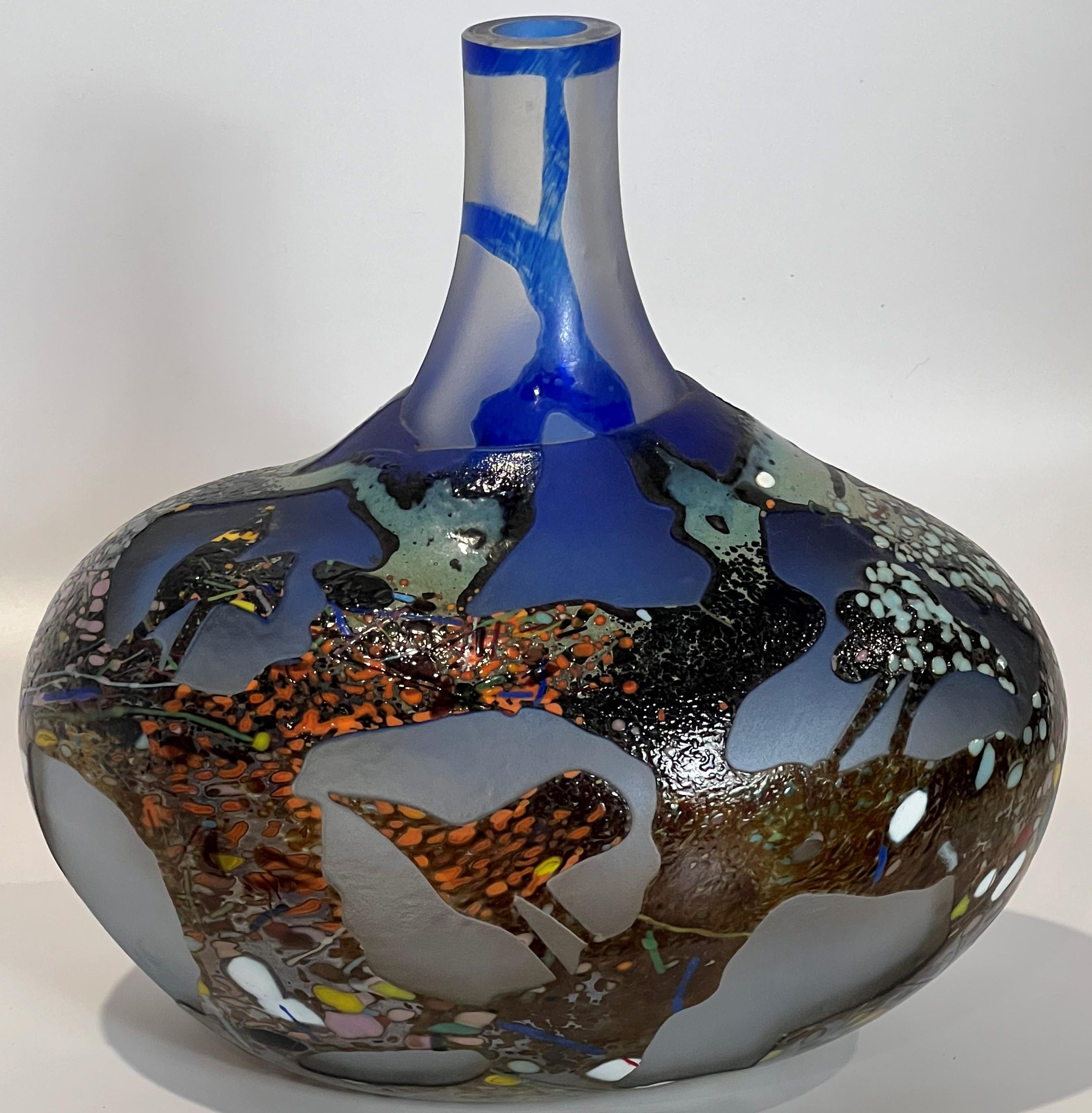 Bertil's work is often haunting, but this bottle vase is ready for display or perhaps for the most adventurous as a container for your personal witch's brew. A entire layer of end of day type scattered glass has been cameo acid cut back to reveal a