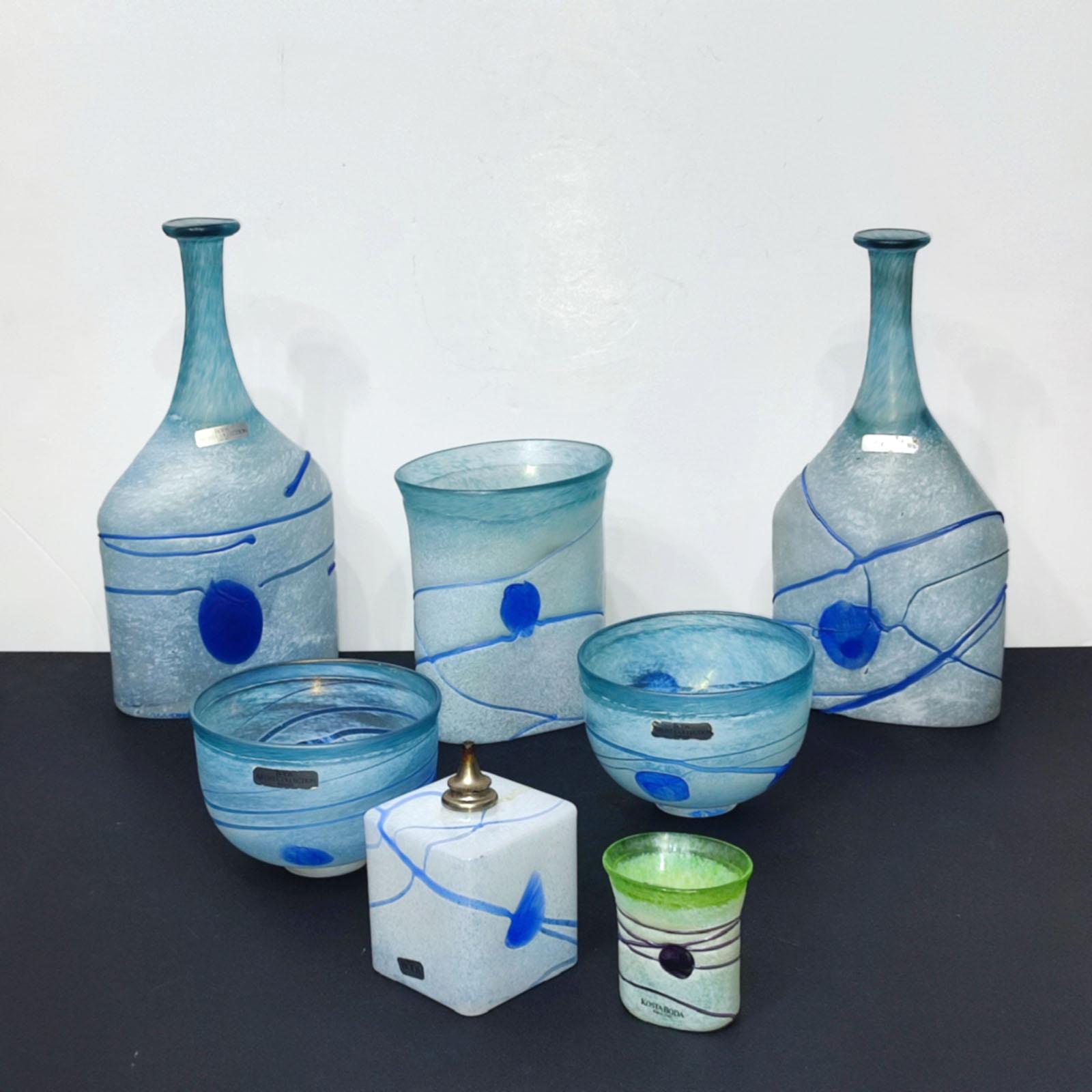 A collection of seven glass pieces by Bertil Vallien for Kosta Boda.
From the one of the most well-known series - Galaxy Blue from 1982. 
It consists of 7 objects with blue threads and dots on a white surface.
2 Bottle Vases (model 48015), height