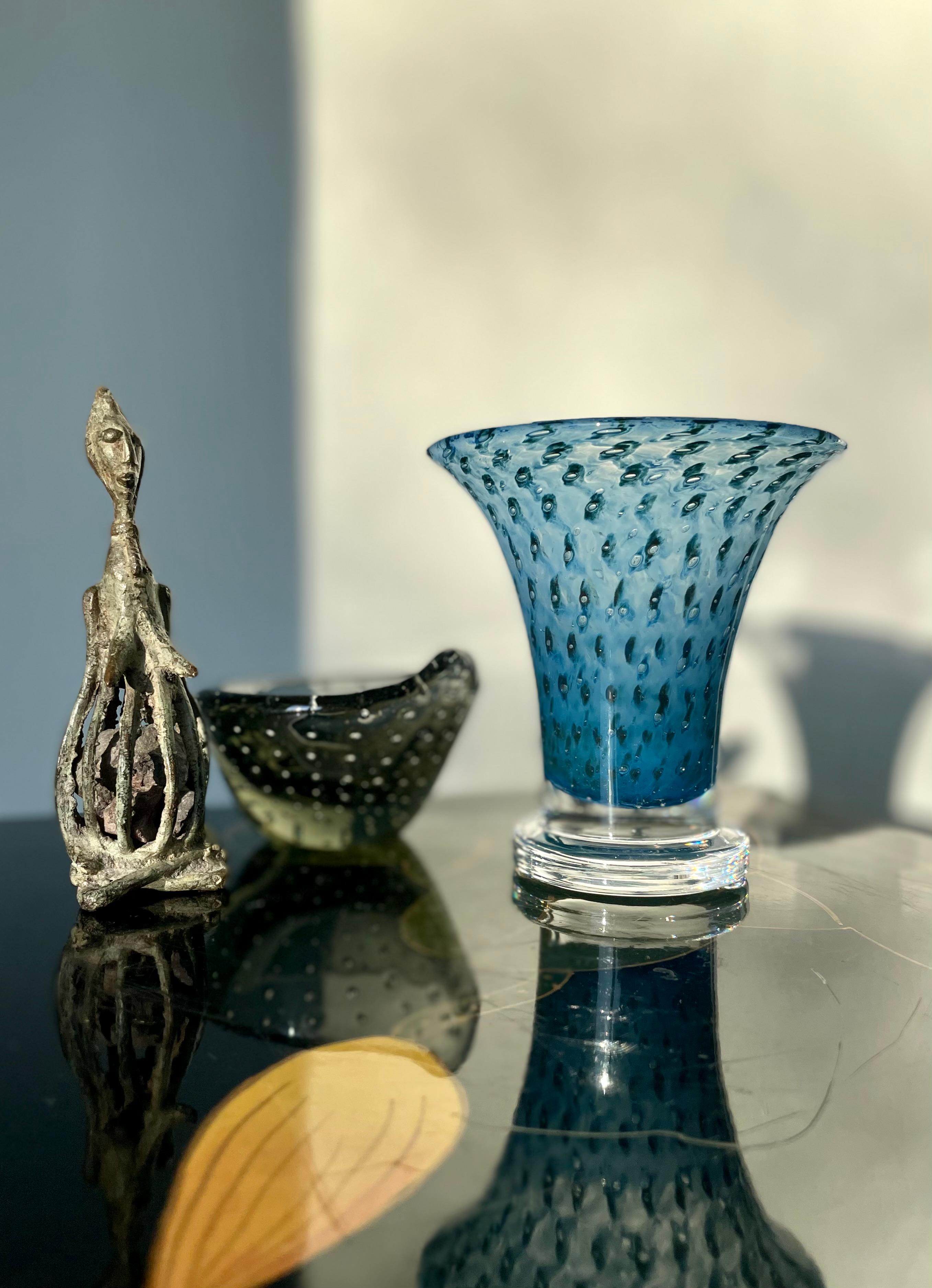 Striking blue, mouthblown controlled bubble art glass vase with decorative black eyes with clear middle resembling the eyes on peacock feathers. Designed and handmade by acclaimed Swedish art glass designer Bertil Vallien for Kosta Boda in the