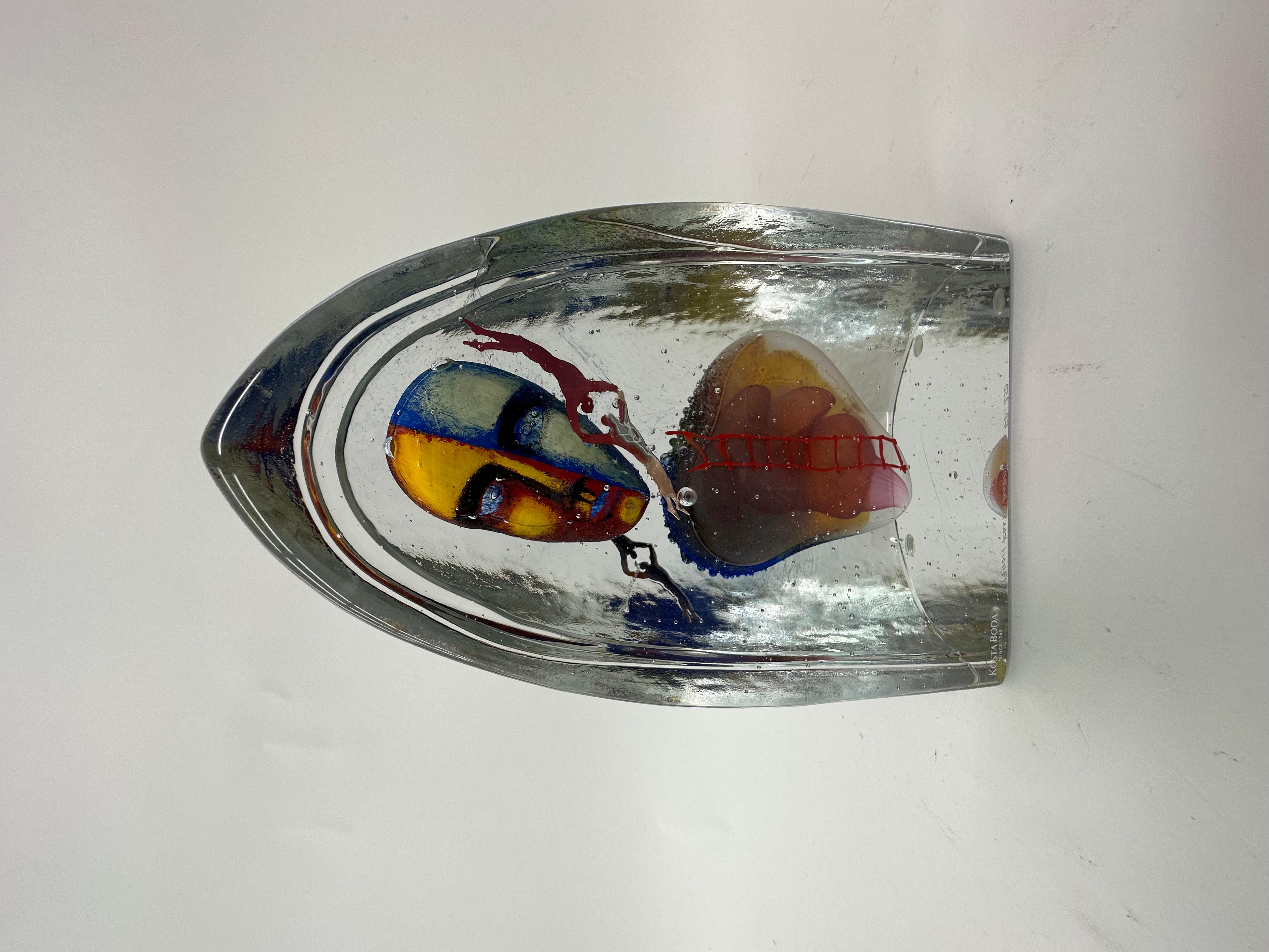 Clear glass with enclosed polychrome decoration of face, heart and two copper figures. Signed  KOSTA BODA Glue. Ed 250, produced in a maximum of 250 copies.
Dimensions: 21 cm H, 14cm W, 9cm D
Condition: Mint