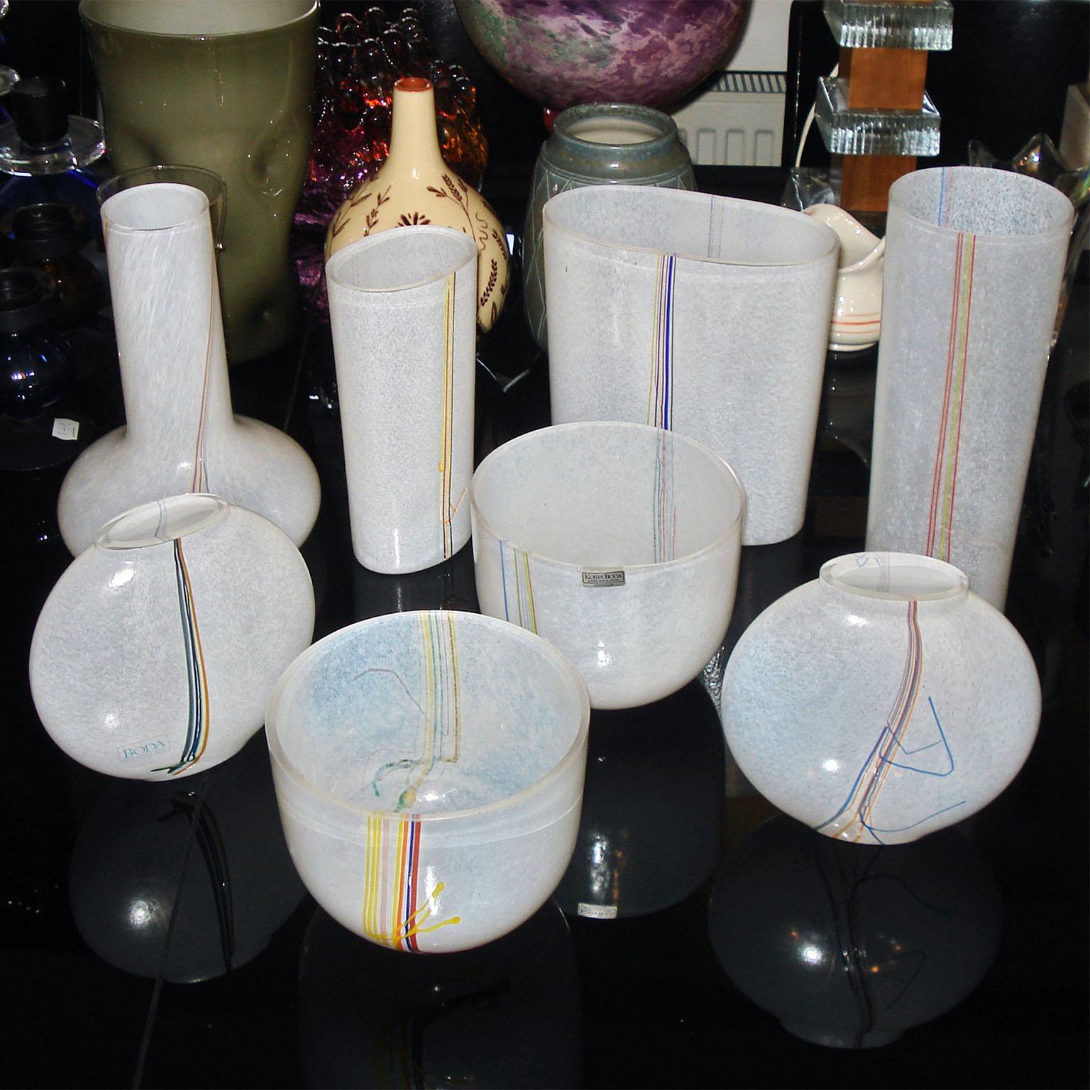 Decorative glass vases with multicolored strands of glass to the sides, designed and made by Bertil Vallien for Kosta Boda. Some of them signed to the bottom, some wearing manufacturer label.