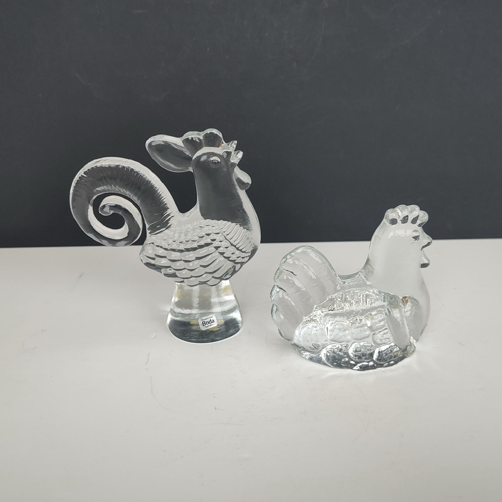 Bertil Vallien pour Kosta Boda - Figurines en verre représentant un coq et une poule, Suède, milieu du XXe siècle.
Les labels d'origine sont toujours en place.
Verre transparent moulé.
Excellent état vintage, sans éclats ni fissures.
Dimensions : 
-