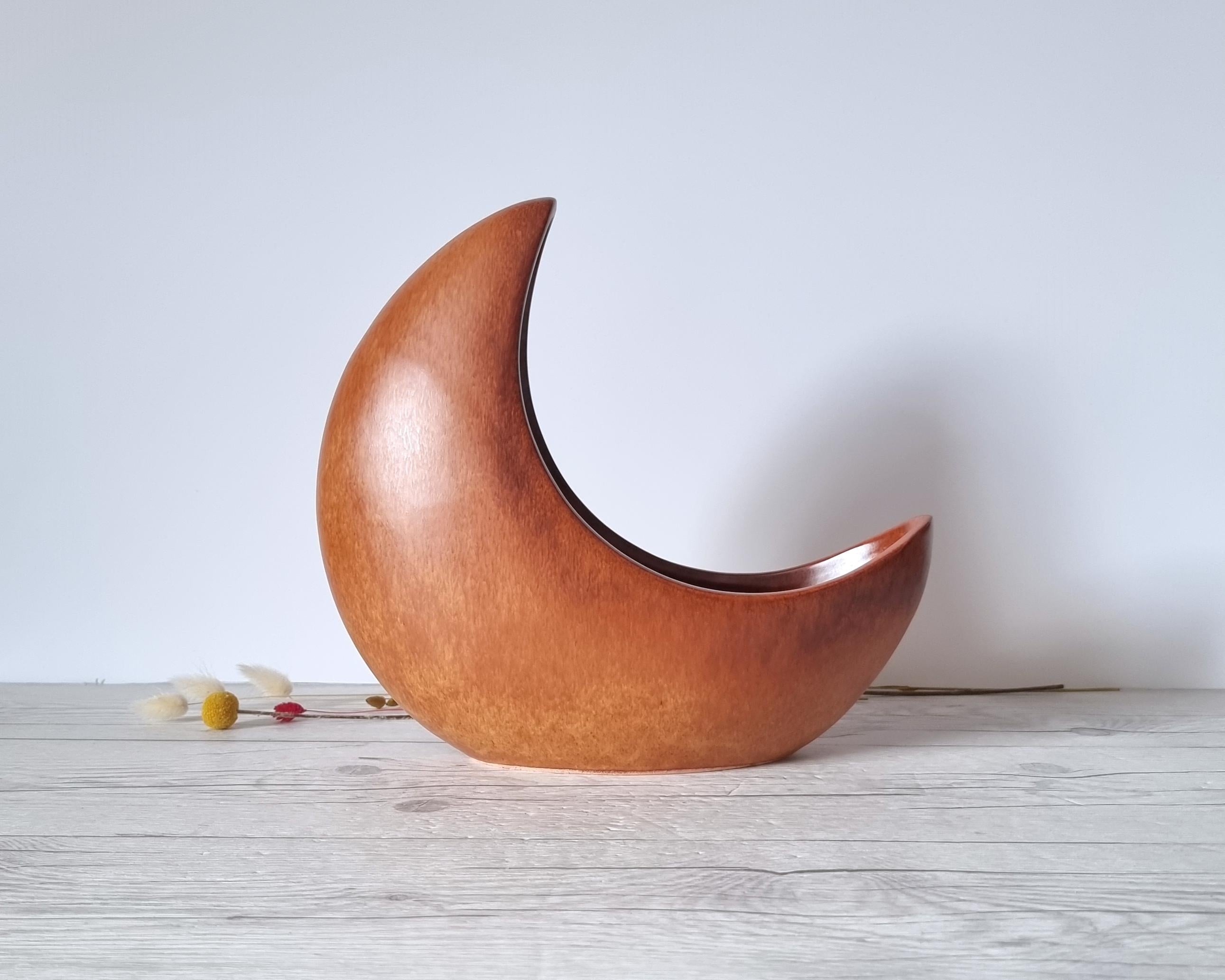 This exceptionally sculptural work of Italian mid-century Modern design by the Bertoncello Ceramiche D'Arte (estd. c.1956 - c.1999). The form is that of a 3D crescent moon partially embedded into the surface the piece rests upon. Further elevating