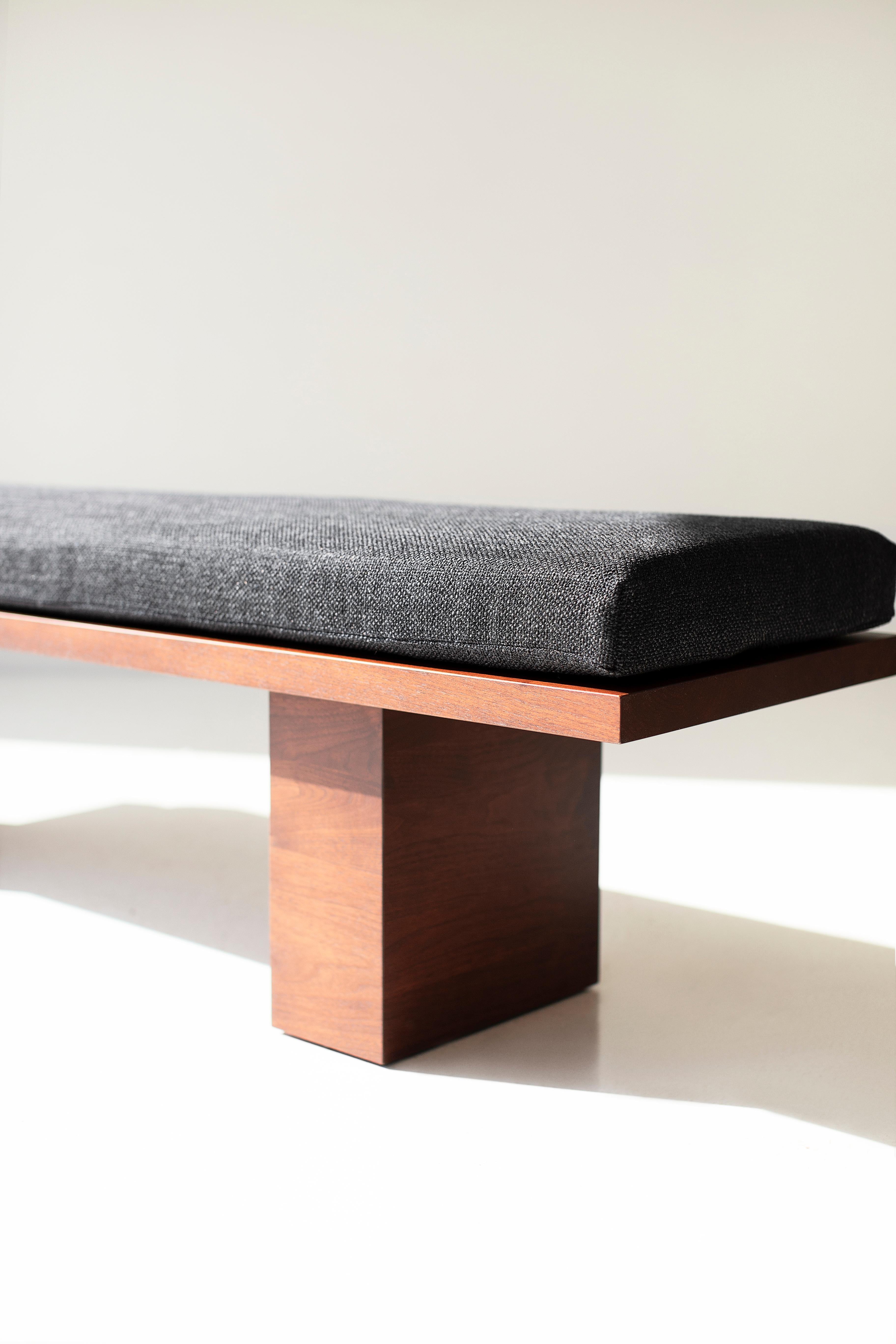 This Modern Walnut Suelo® Bench is beautifully constructed from solid wood in Ohio, USA. This walnut silhouette is simple, modern, and sleek, topped with a comfortable cushion. The Suelo® Collection consists of an arm chair, side chair, bench,