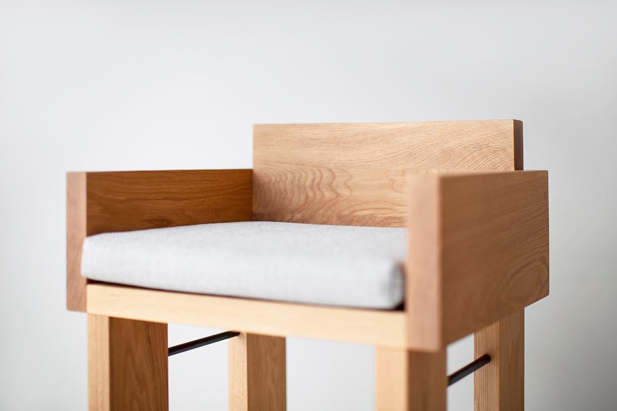This White Oak Chile Counter Stool is beautifully constructed from solid wood in Ohio, USA. The stool is chunky and modern with a comfortable cushion in the thick weave fabric color of your choice. Sleek black metal rods complete the frame for