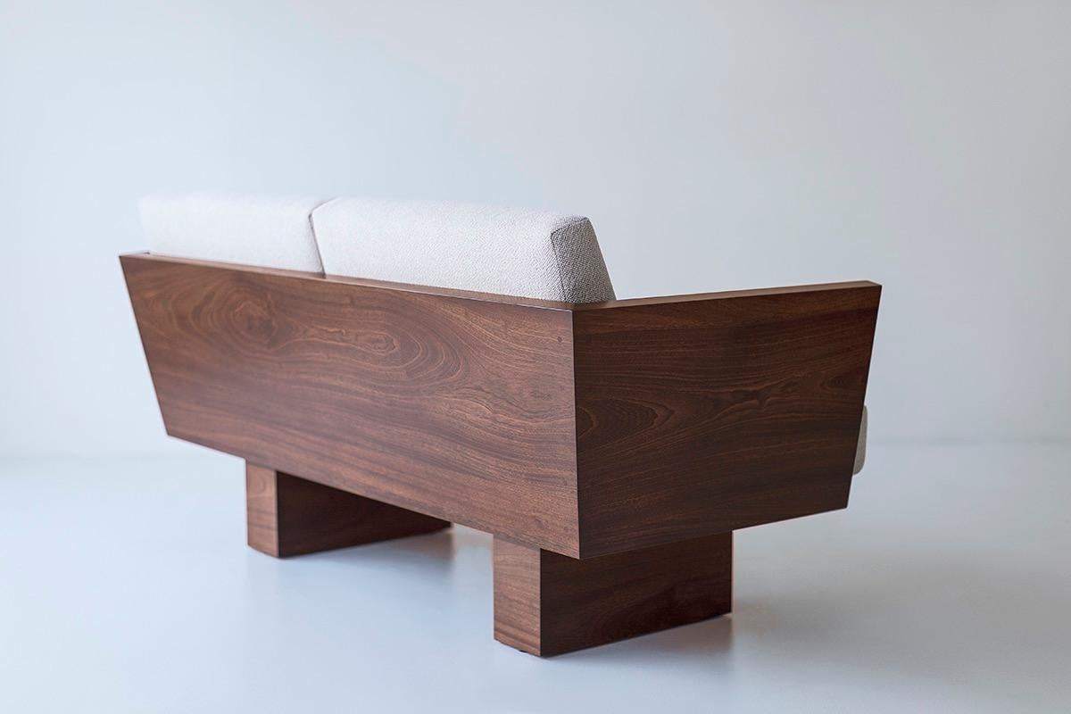 Questa poltrona da esterno Suelo® con braccioli è costruita in legno massiccio in Ohio, USA. La silhouette di questo divano è semplice, moderna ed elegante, con comodi cuscini per lo schienale e la seduta. La struttura in legno è adatta agli