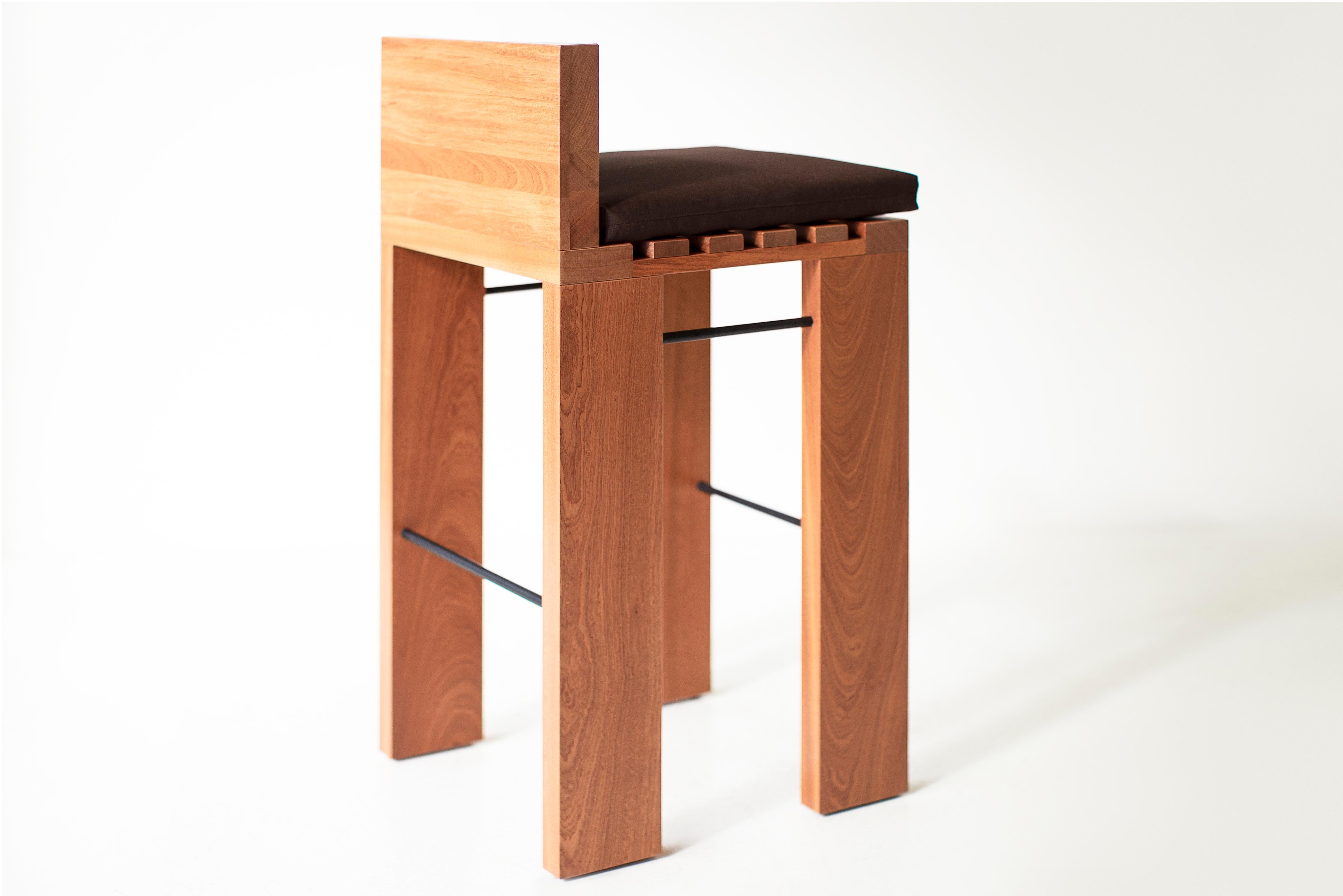 Estos taburetes de bar para exterior Chile en color natural están fabricados con madera maciza en Ohio (EE.UU.). El taburete de bar es grueso y moderno, con un cómodo cojín para uso en exteriores. Las varillas de metal negro completan el armazón