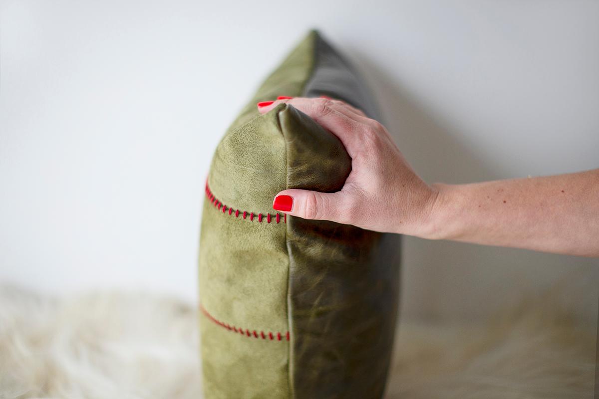 Dieses Suede Holiday Throw Pillow wird im Herzen von Ohio, USA, mit einer Vorderseite aus Wildleder und einer Rückseite aus hochwertigem Leder hergestellt. Das Muster der Nähte zwischen den 3 Lederelementen ist das, was sie zum Leuchten bringt. Sie