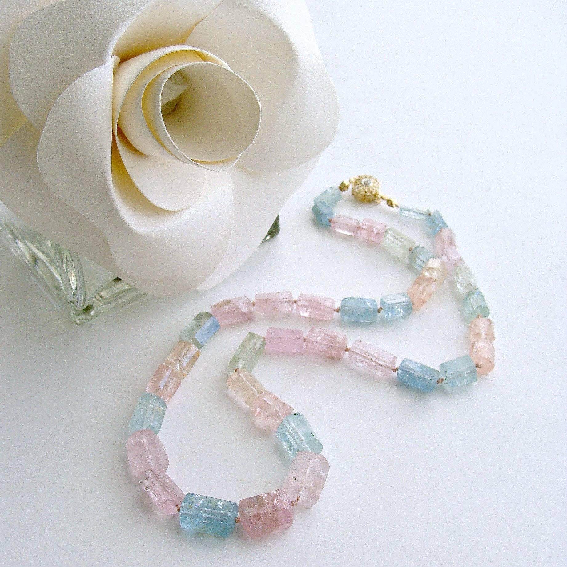 Bella Necklace.

A confectionary pastel suite of graduated beryl faceted tubes in soft blue/green aquamarine and delicate pink morganite have been hand-knotted to create this delicious candy-colored necklace.  The dainty filigree 14K gold box safety