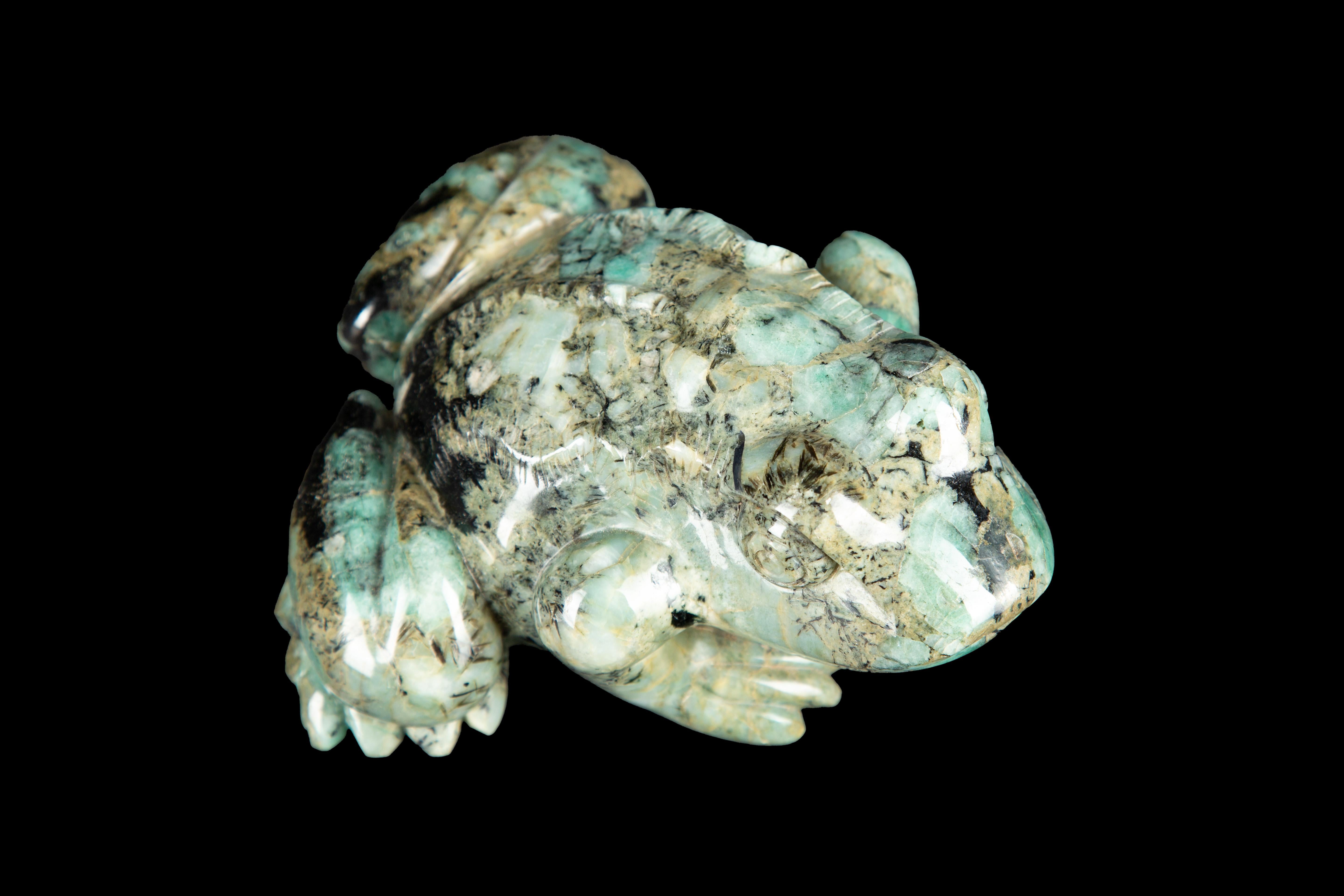This Carved Beryl Emerald Frog is a stunning work of art that showcases the beauty and intricacy of carved gemstones. Made from beryl emerald, this frog figurine is expertly crafted and features intricate details that are sure to impress anyone who