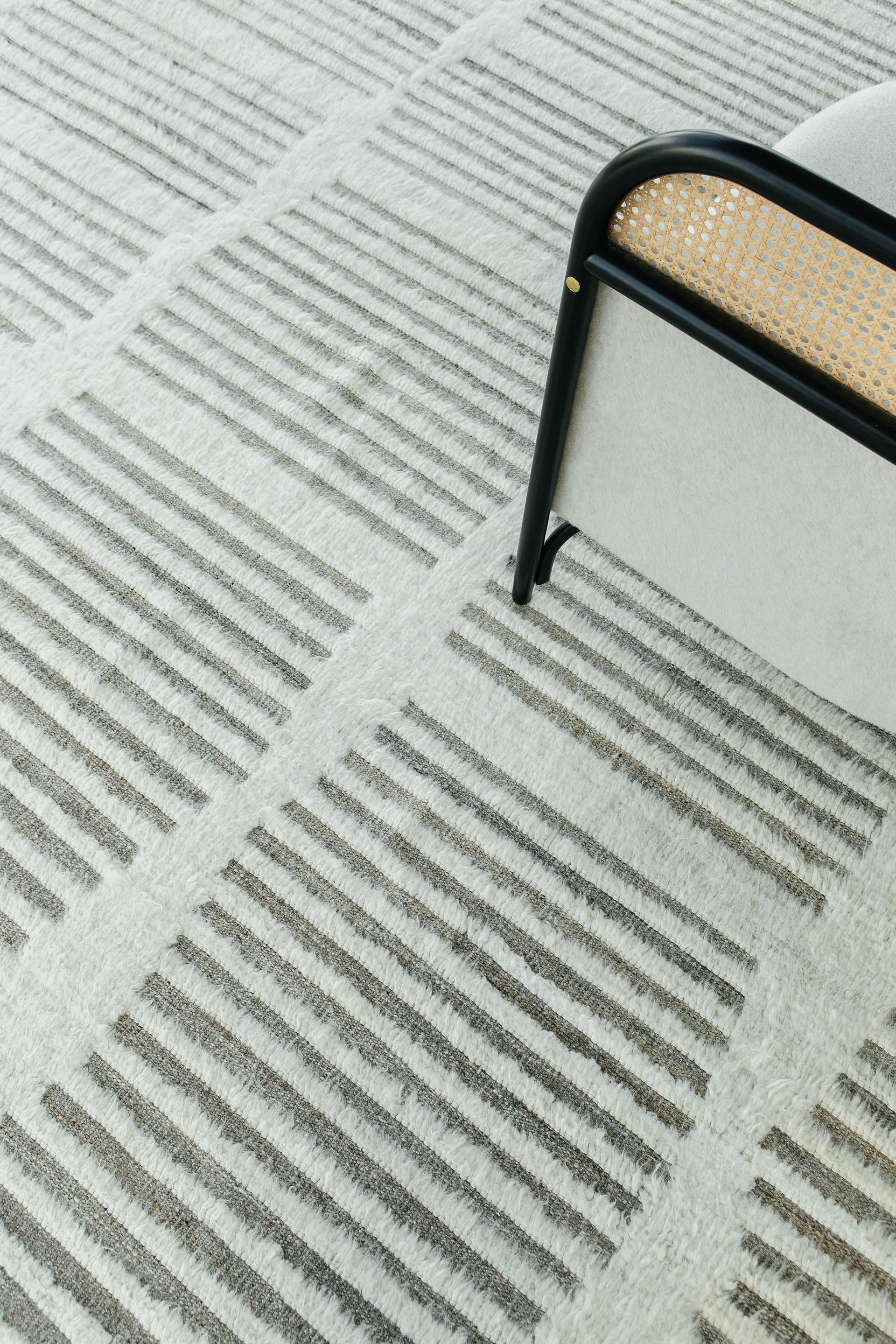 Handwoven of wool, Beshabar uses linework and color to create definition and movement. Embossed natural-toned detailing move across our perfect ivory-colored shag surface. Mehraban's Haute Bohemian collection is designed in Los Angeles and named for