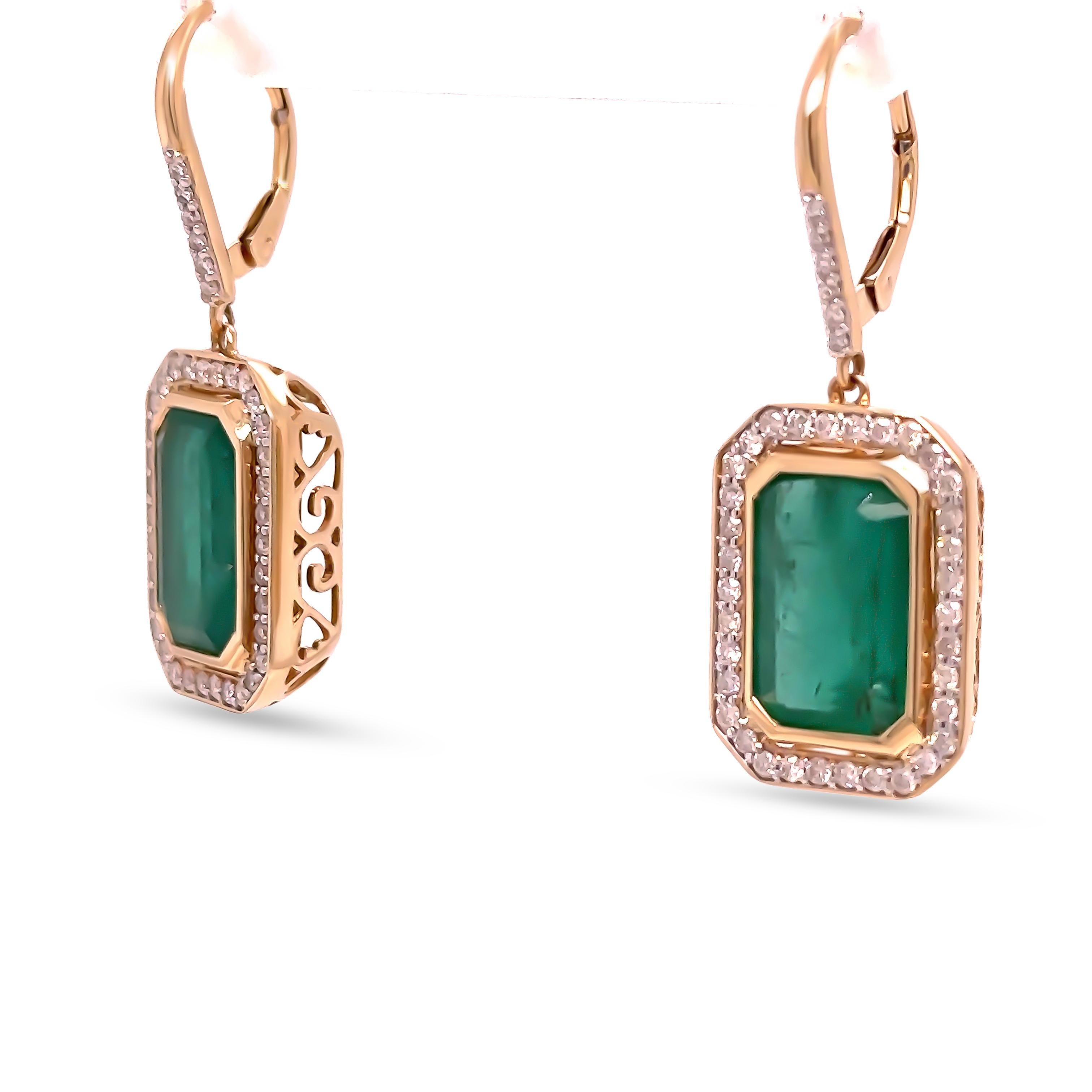 Un paio di orecchini con smeraldo e diamanti, realizzati in oro giallo 14ct. Ciascun orecchino è incastonato con uno smeraldo naturale tagliato a castone, di colore verde di media intensità, del peso di 5,00ct ciascuno, per un totale di