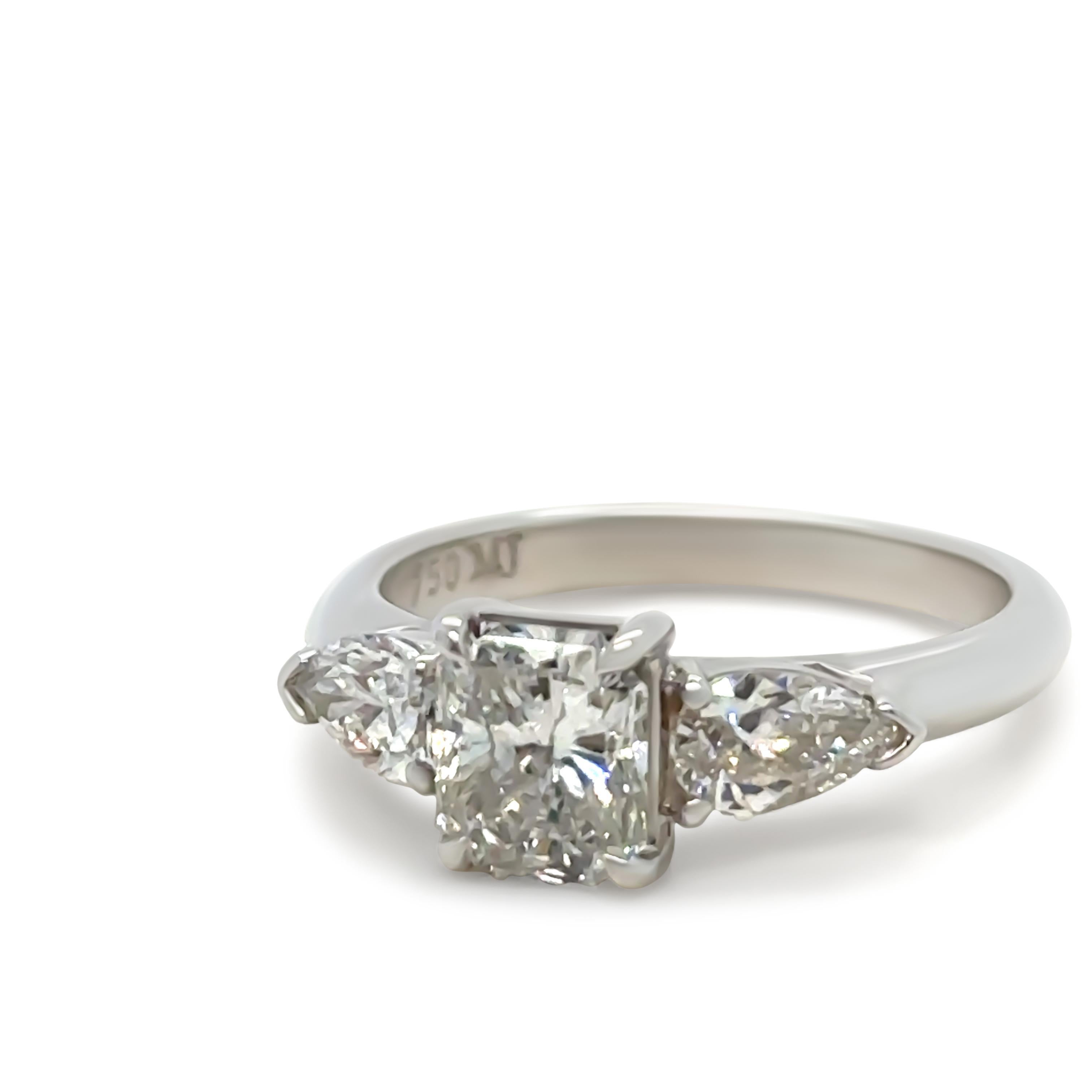 Bague de fiançailles en or blanc 18 ct, faite sur mesure et ornée de diamants. Serti d'un diamant central de taille Brilliante, couleur F, pureté VS avec un poids en carats de 1.04ct. Serti de 2 diamants poire de taille Brilliante, de couleur F et