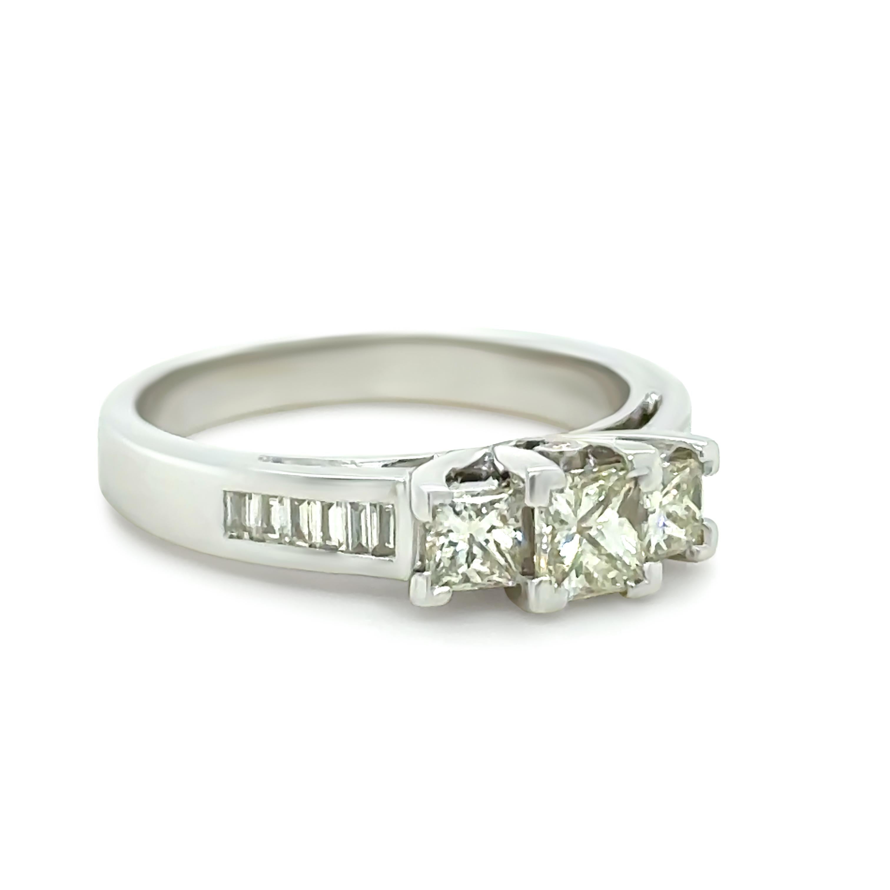 A Bespoke Diamond Trilogy Ring, made of 18ct White Gold. Featuring one Princess Cut Diamond in a four claw setting weighing 0.40ct, with two Princess Cut Diamonds in claw settings on the sides weighing 0.20ct each.

Additionally set with twelve